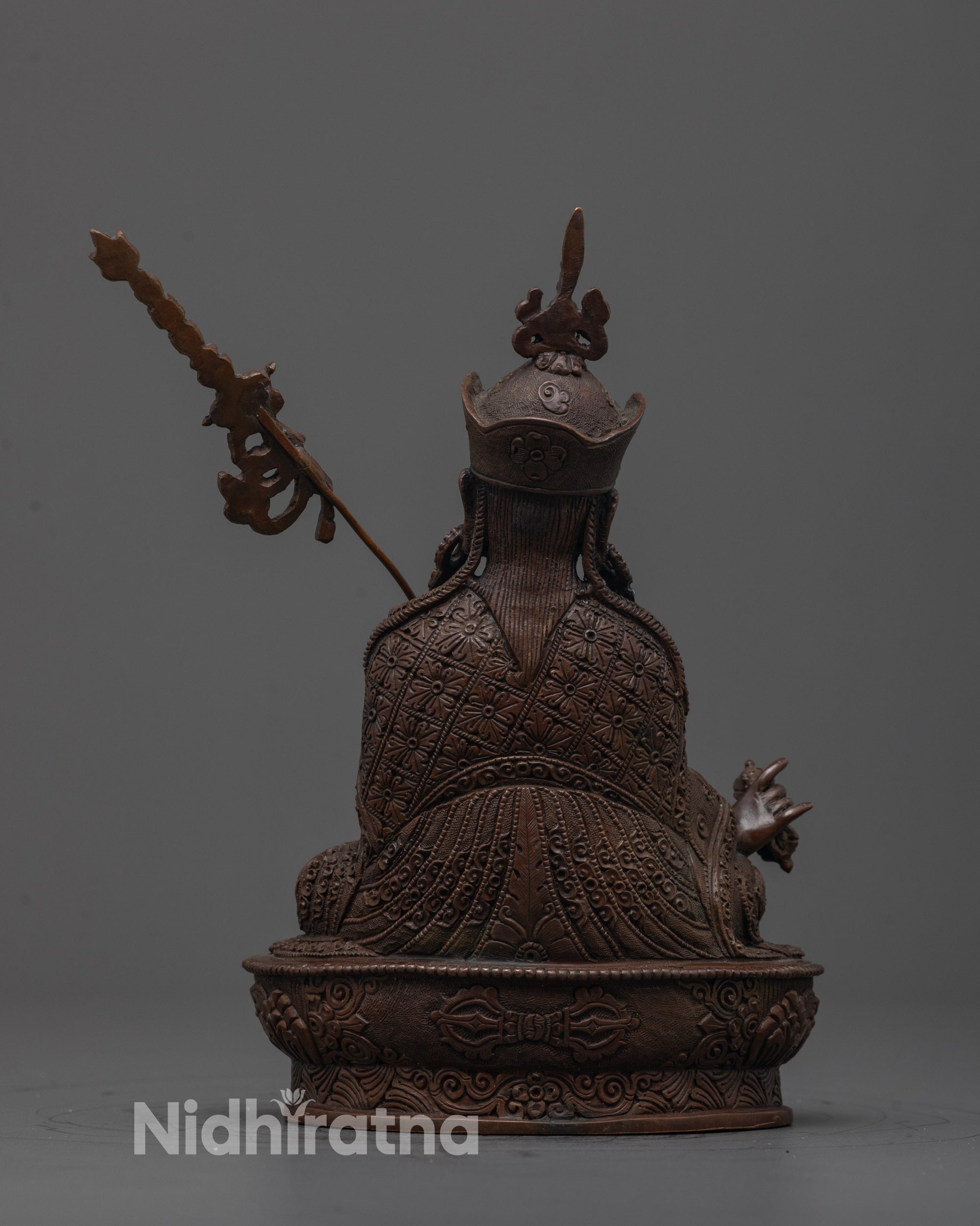 Back view of Padmasambhava Statue showing detailed robes, crown, and oxidized copper craftsmanship