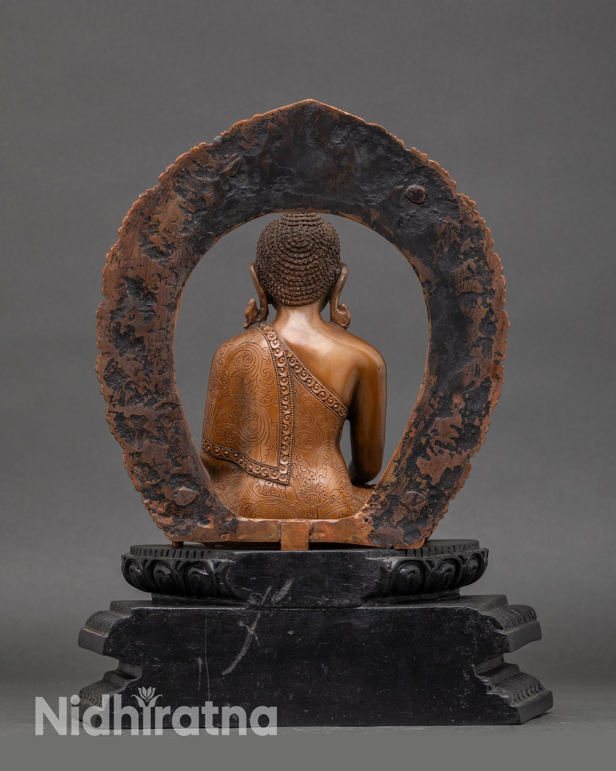 Back view of Shakyamuni Buddha on dark wood frame showing halo and lotus details