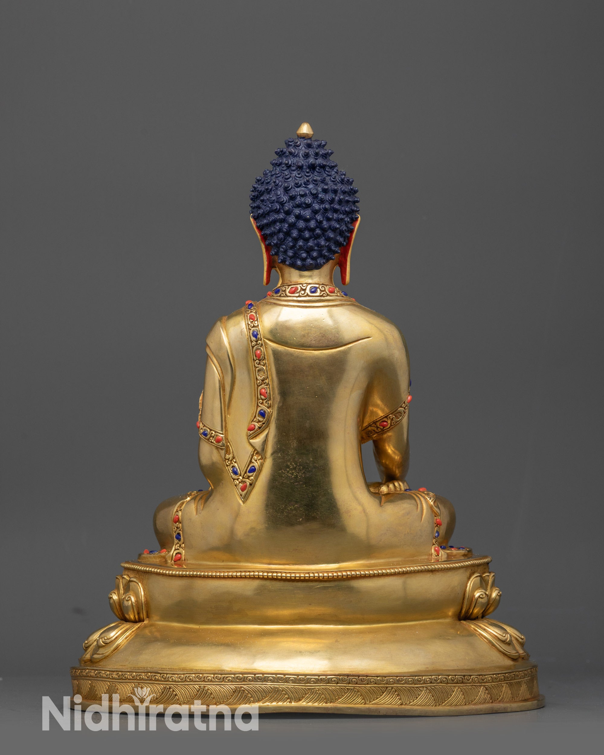 Back view of Shakyamuni Buddha statue highlighting carved robe patterns and lotus base