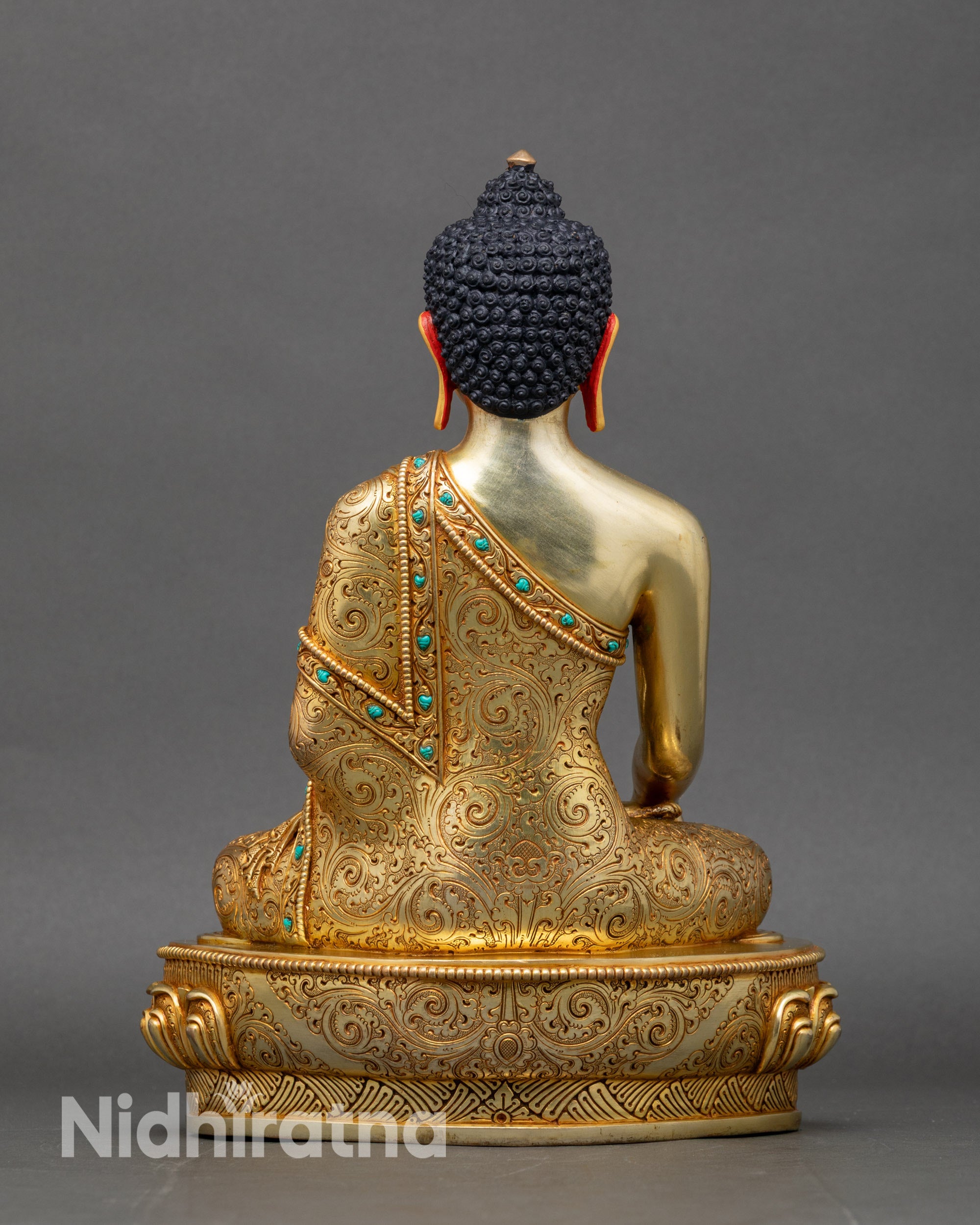 Back view of Shakyamuni Buddha statue with engraved robe details and pedestal