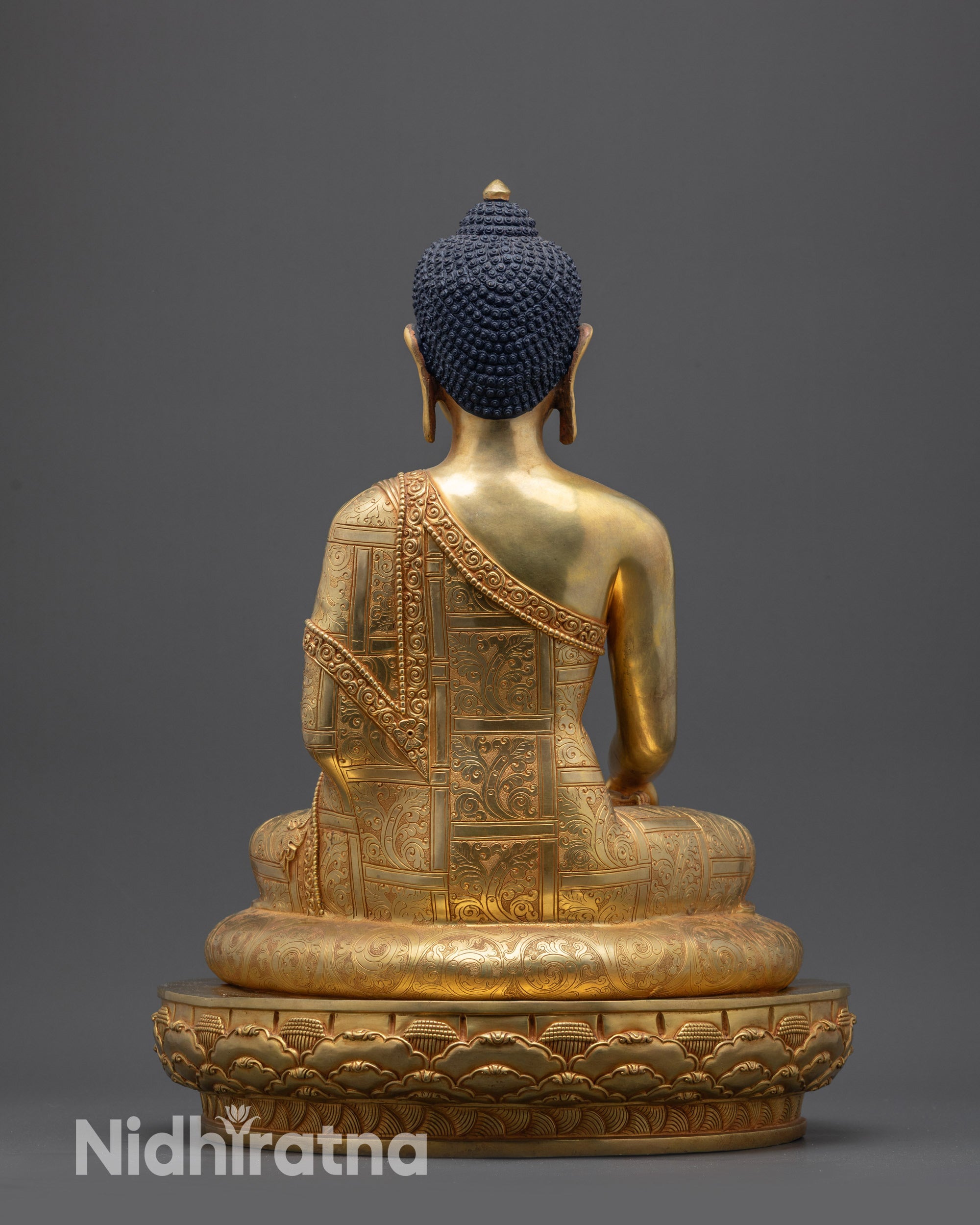 Back view of Siddhartha Gautama Buddha statue with detailed robe and lotus base