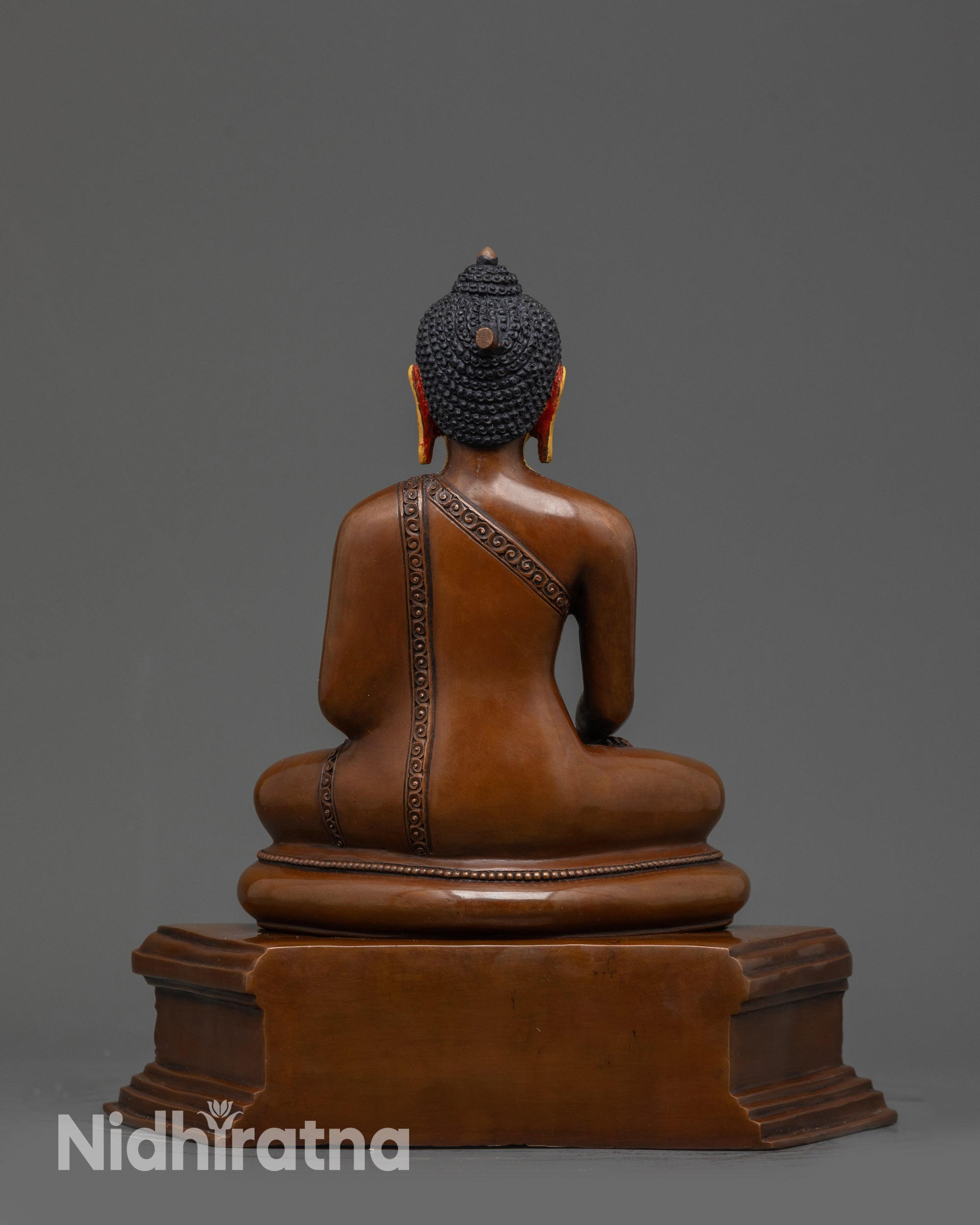 Back view of Tibetan Buddhist Shakyamuni Buddha statue showing oxidized copper details