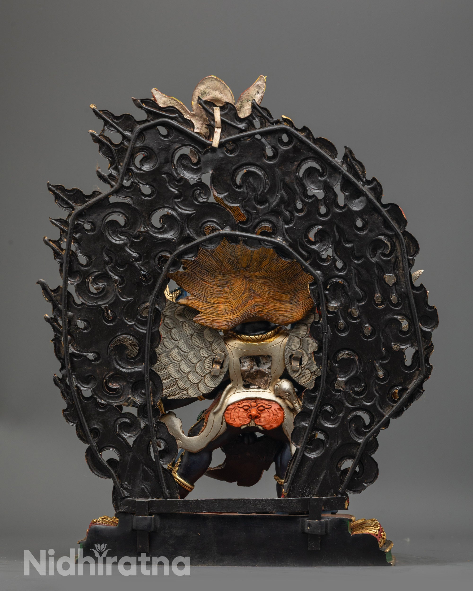 Back view of Tibetan Vajrakilaya statue showing intricate blazing halo and miniature Garuda