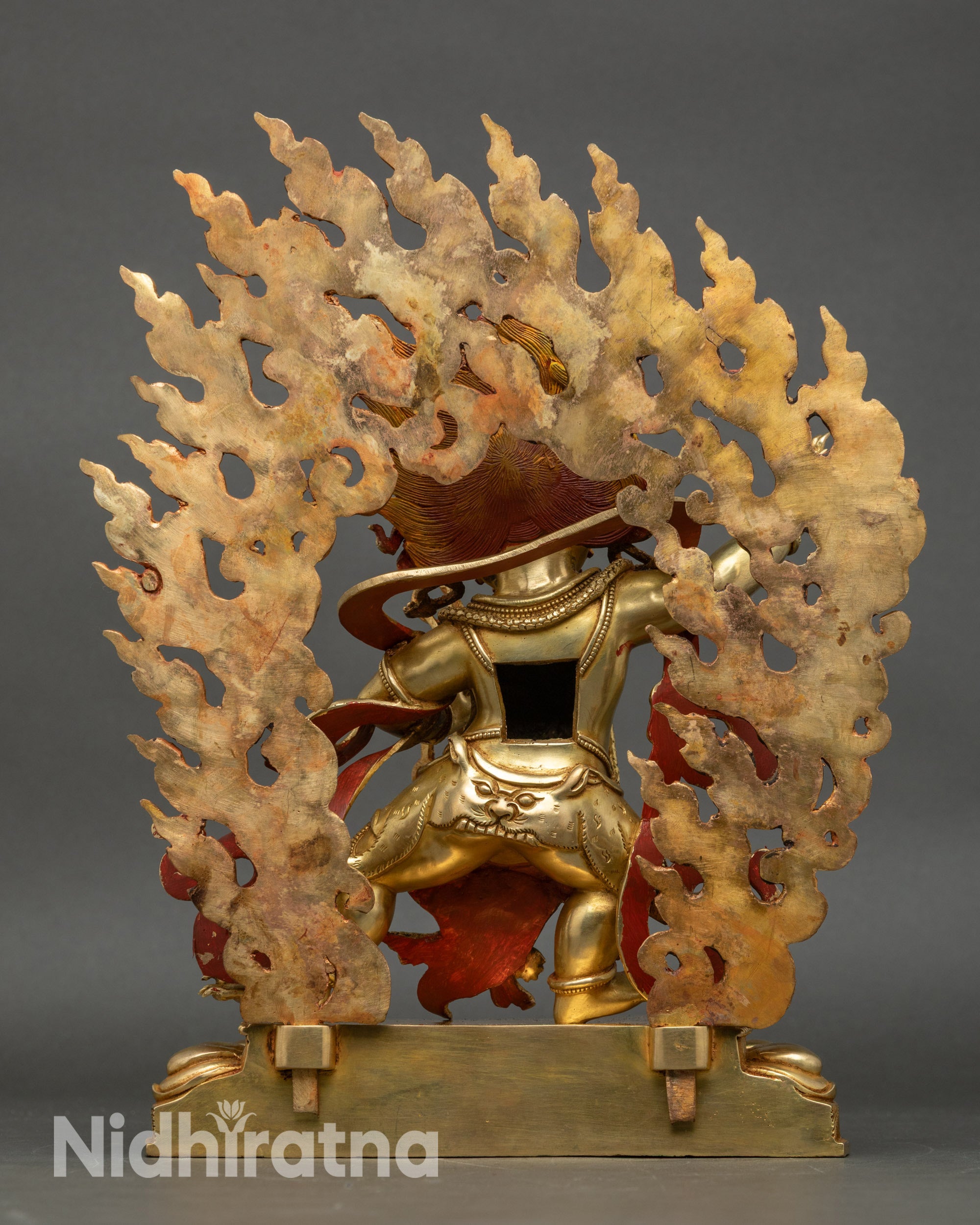Back view of Vajrapani statue showing halo and detailed three-dimensional carvings