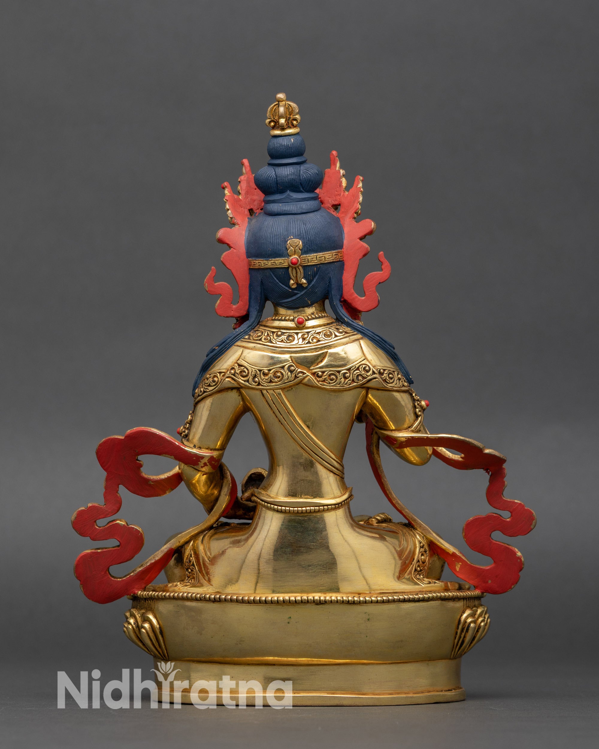 Back view of Vajrasattva statue showing carved lotus pedestal and jewelry details