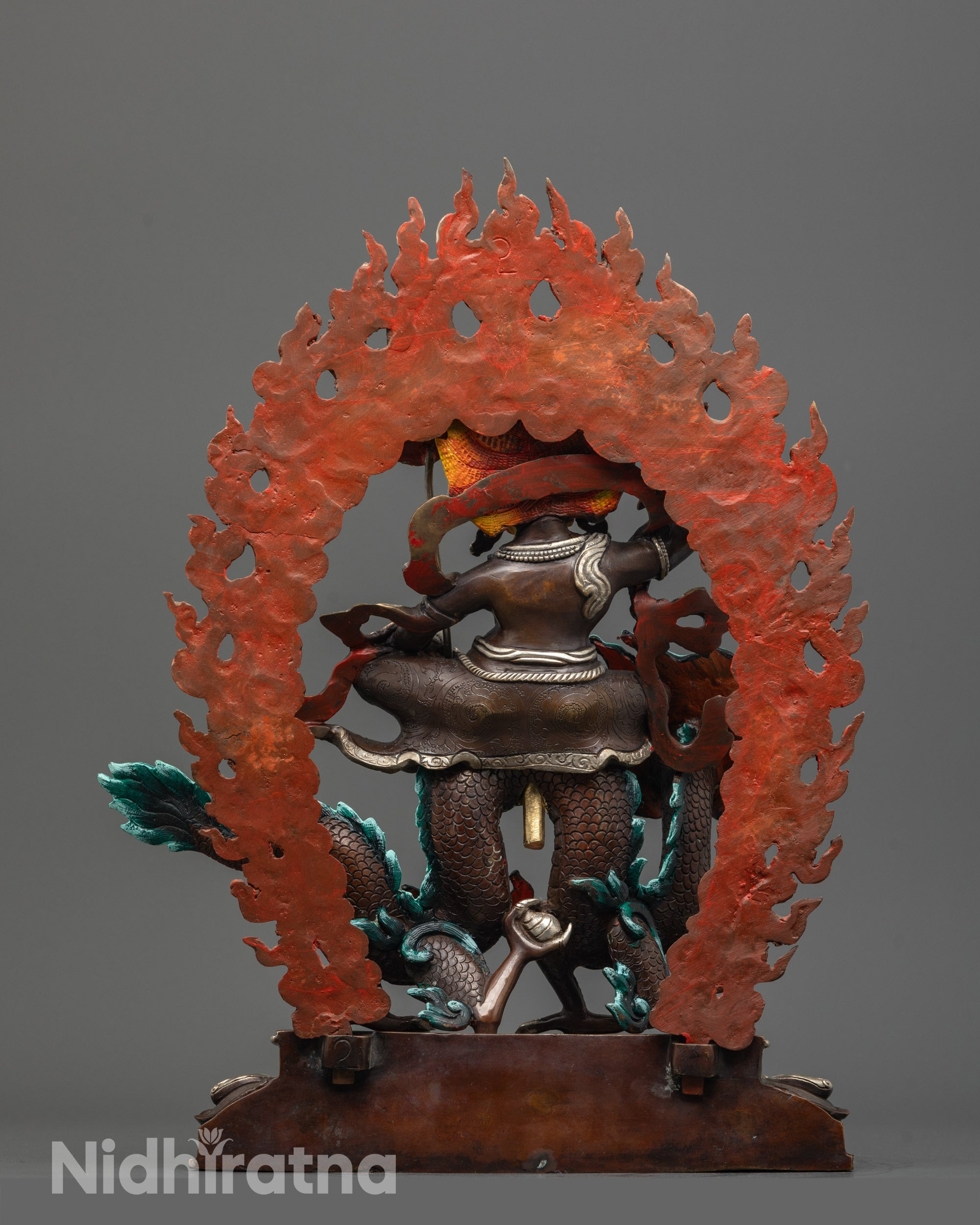 Back view of White Dzambhala Statue highlighting skull crown and blazing halo carvings.