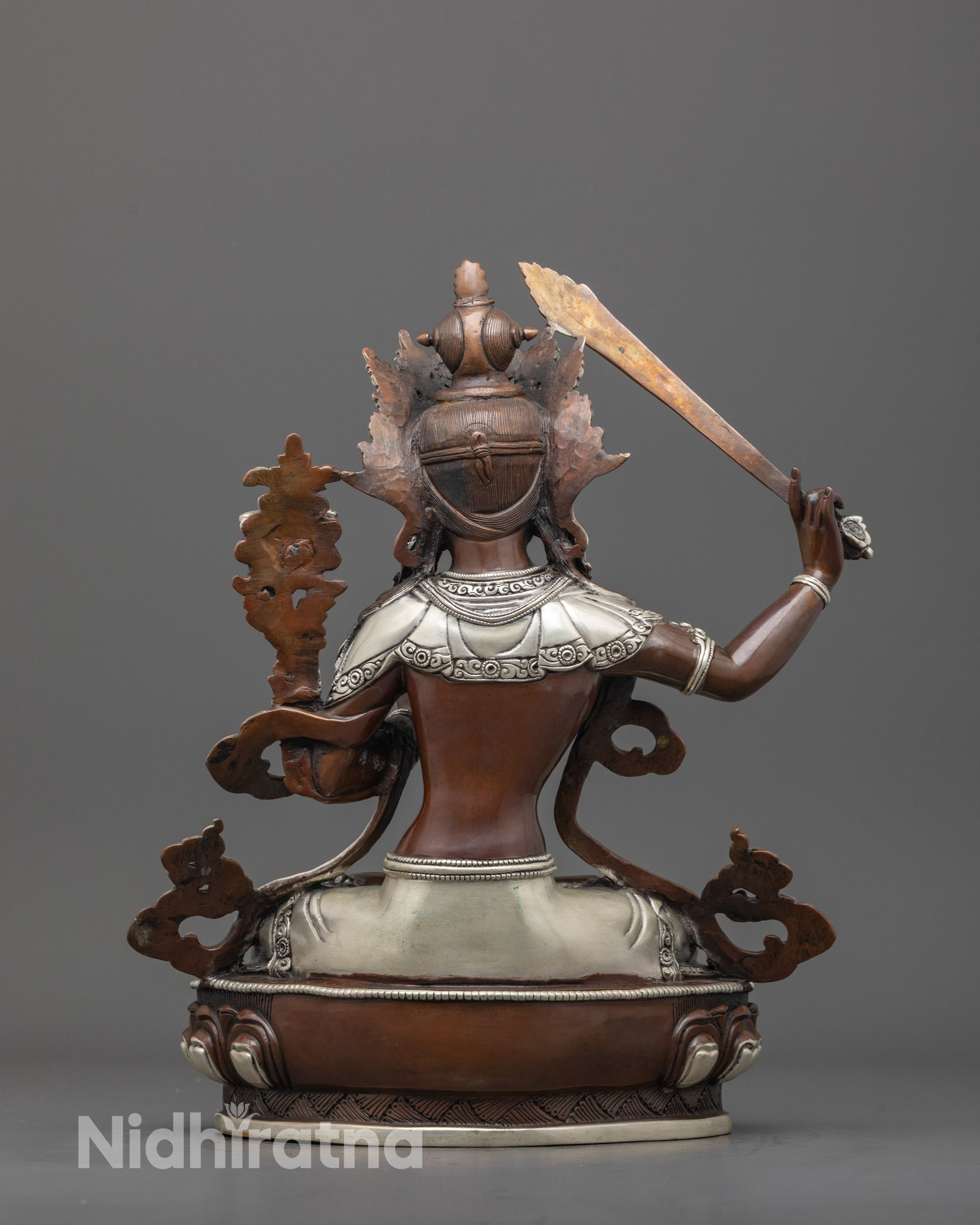 Back view of detailed Manjushri sculpture with oxidized copper and fine silver accents