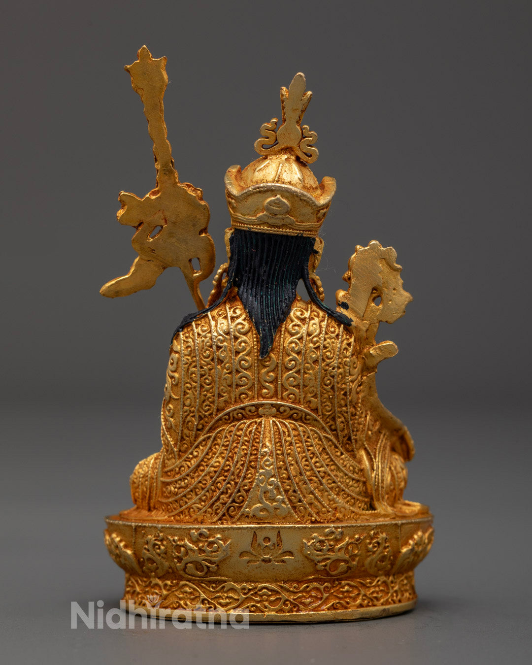 Back view of electroplated Guru Menla statue with intricate robe and throne carvings