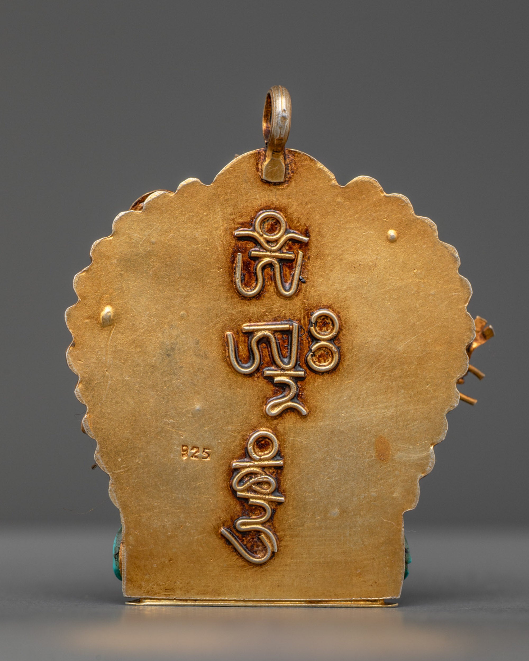 Back view of gold-gilded Ganesha amulet with traditional filigree carving from Patan, Nepal