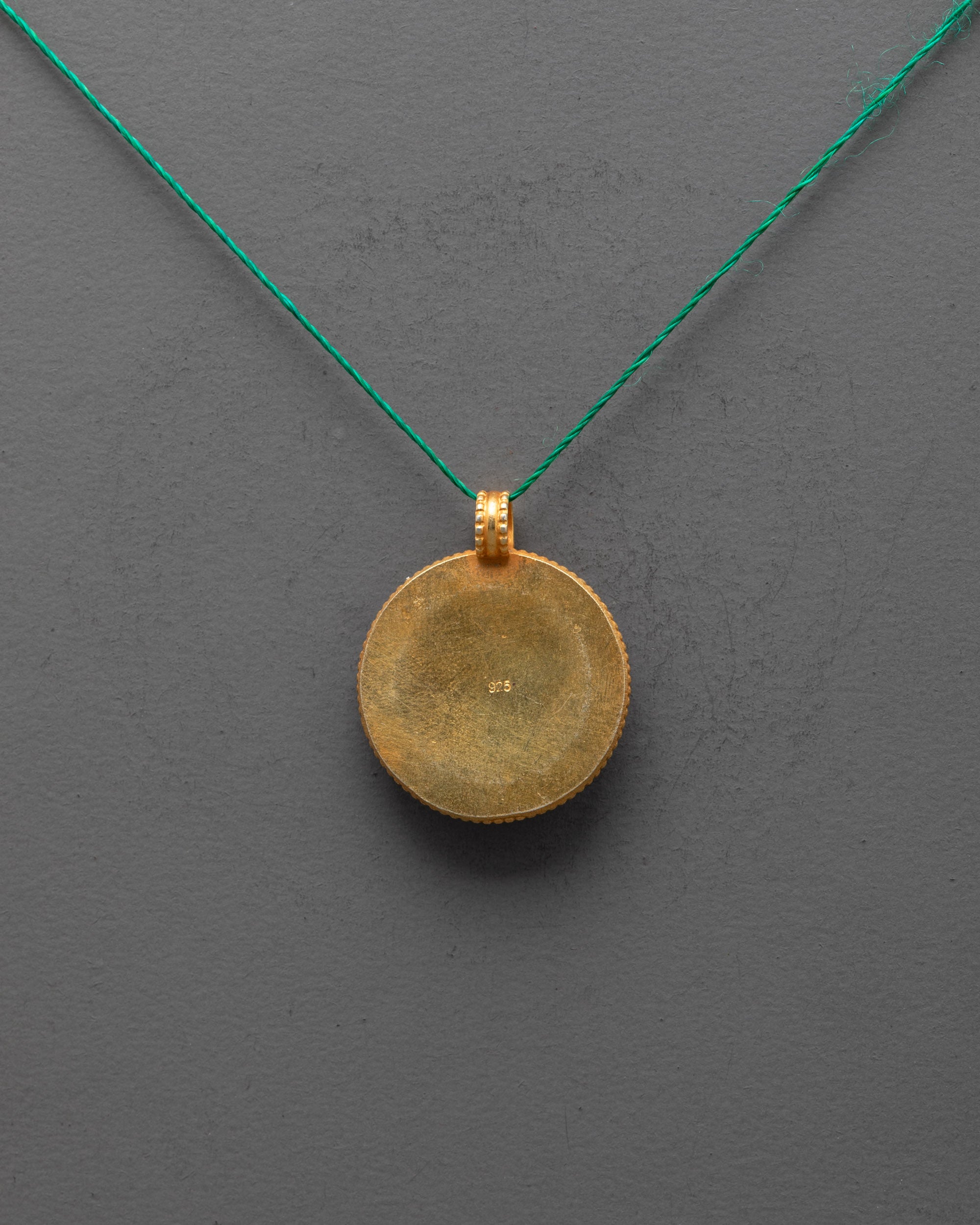 Back view of gold-plated Lotus Locket highlighting artisan carving and smooth finish