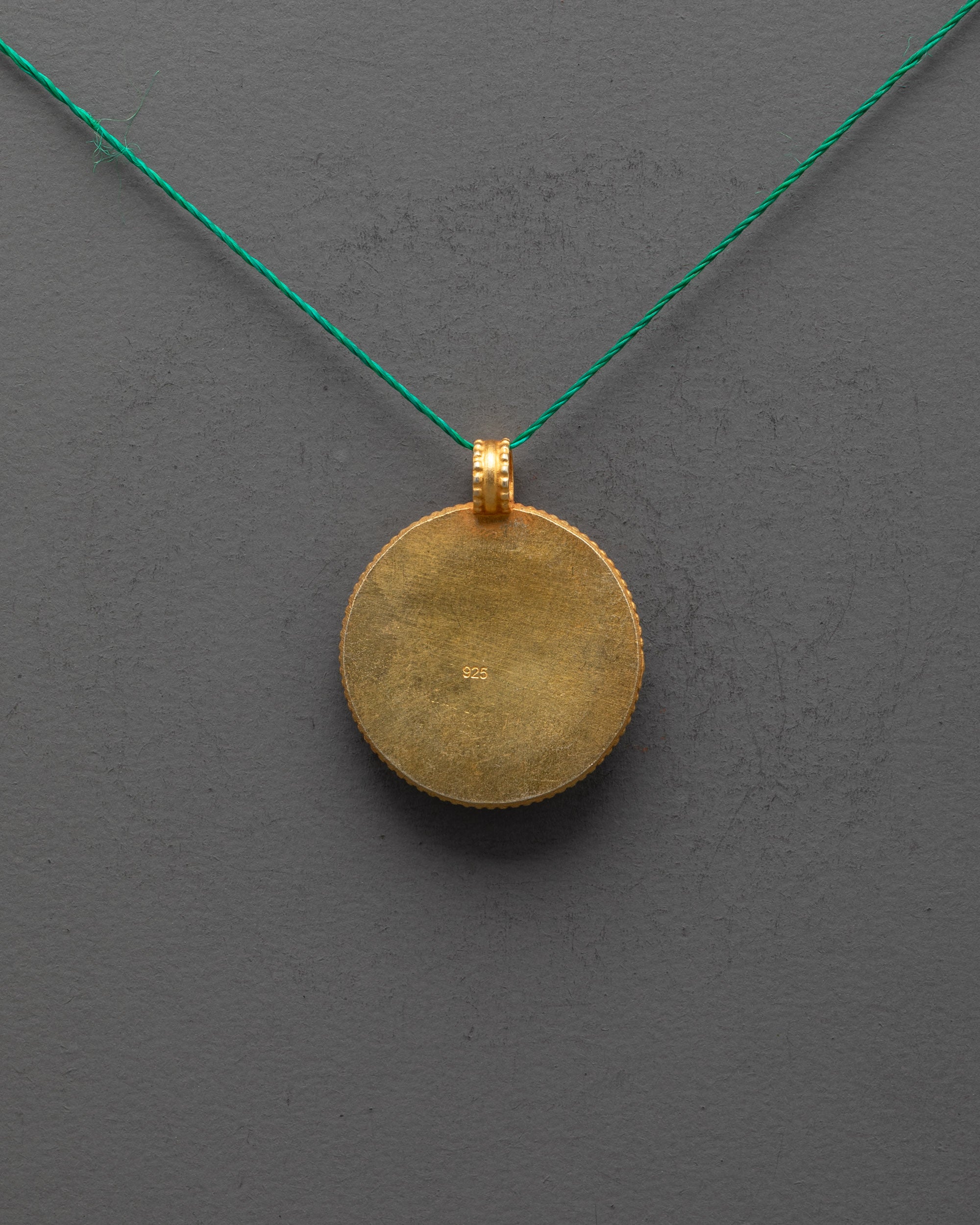 Back view of gold-plated copper Victory Banner Pendant highlighting artisan craftsmanship