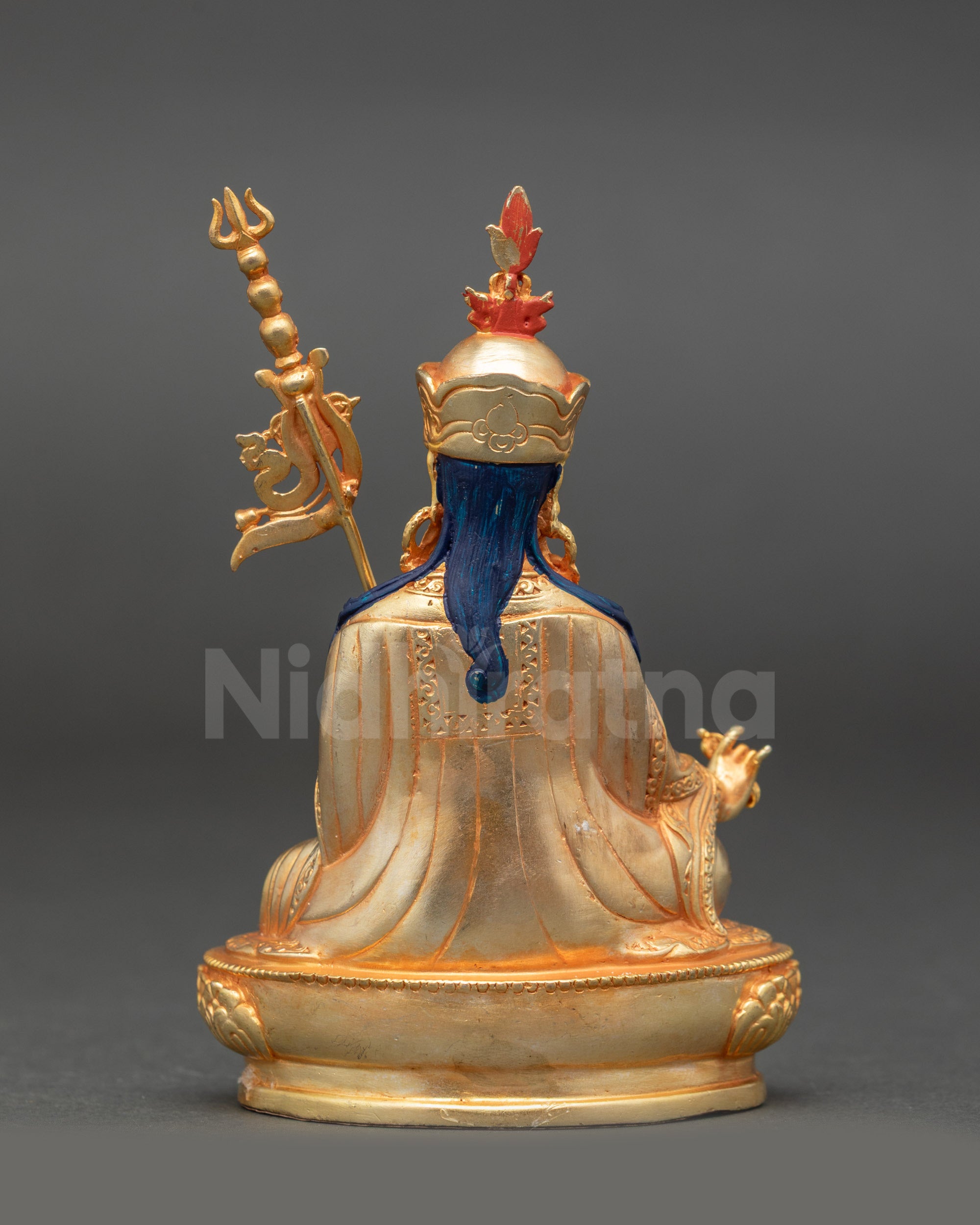 Back view of gold fire-gilded Guru Rinpoche seated on lotus with intricate detailing