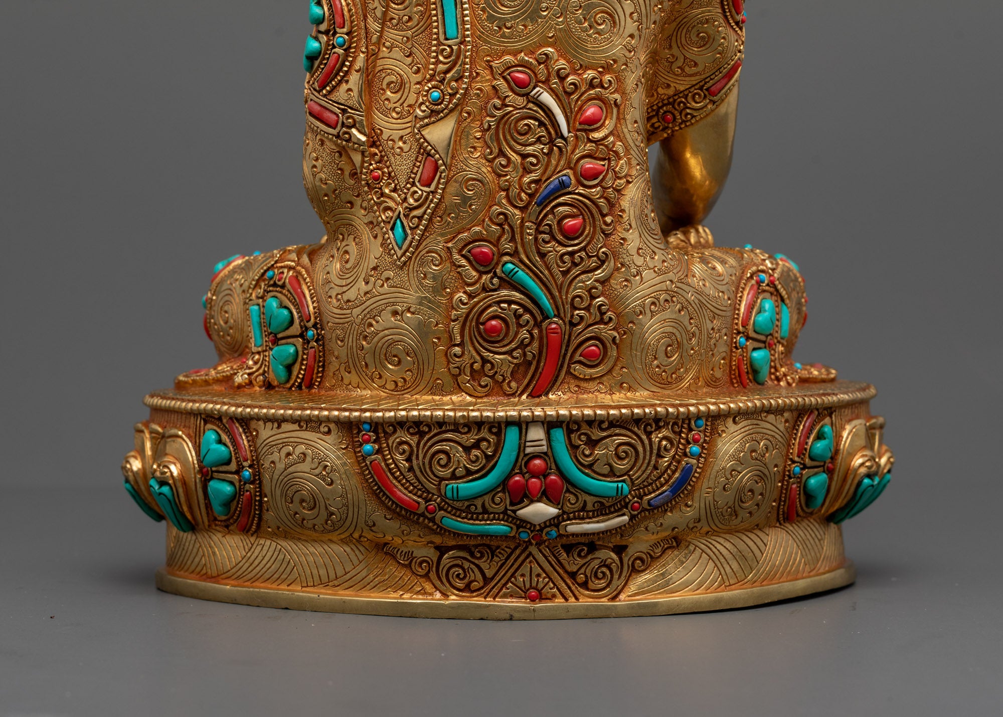 Back view of gold fire-gilded Shakyamuni statue highlighting intricate robe carvings