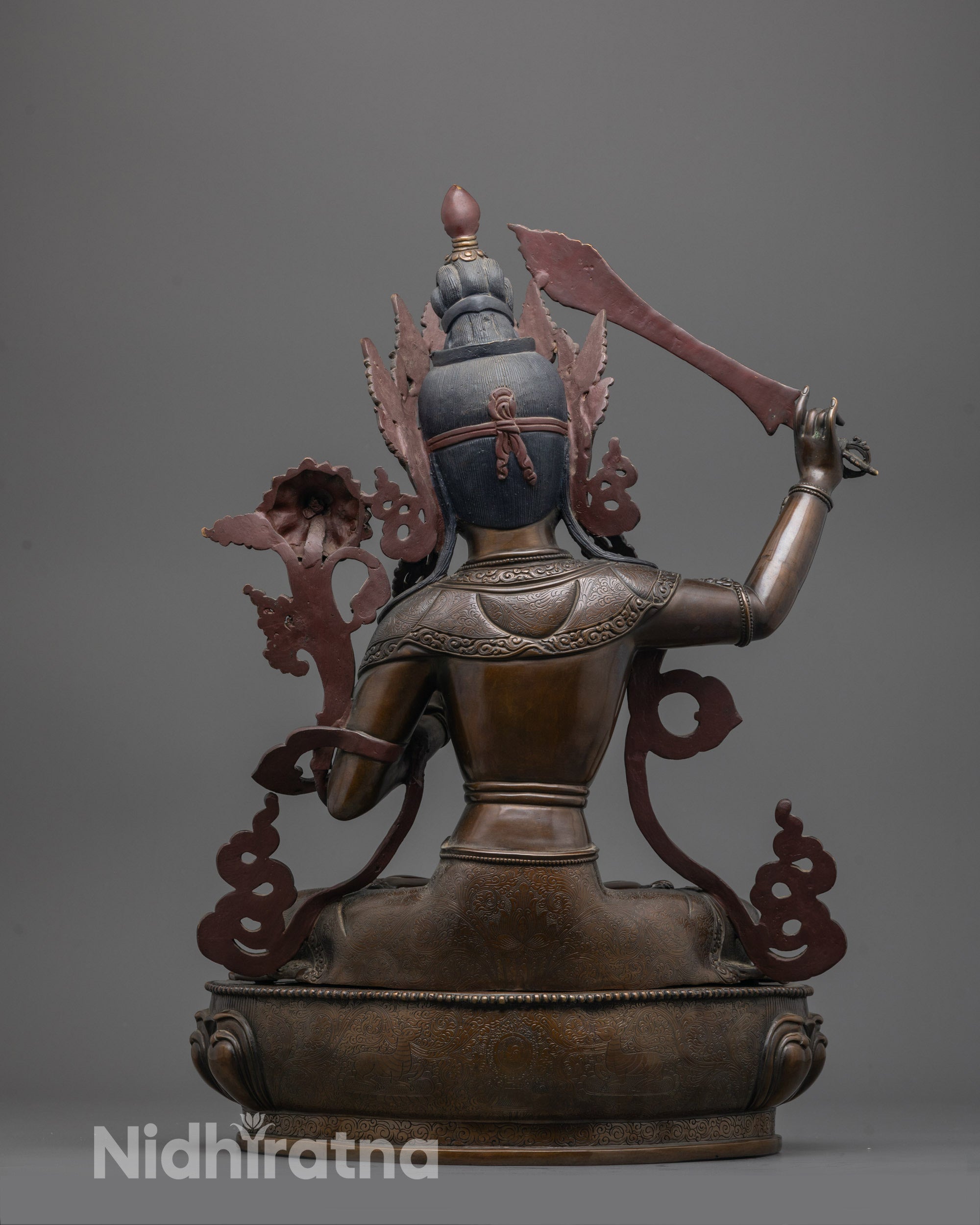 Back view of handcrafted Manjushri statue with oxidized copper texture and lotus seat