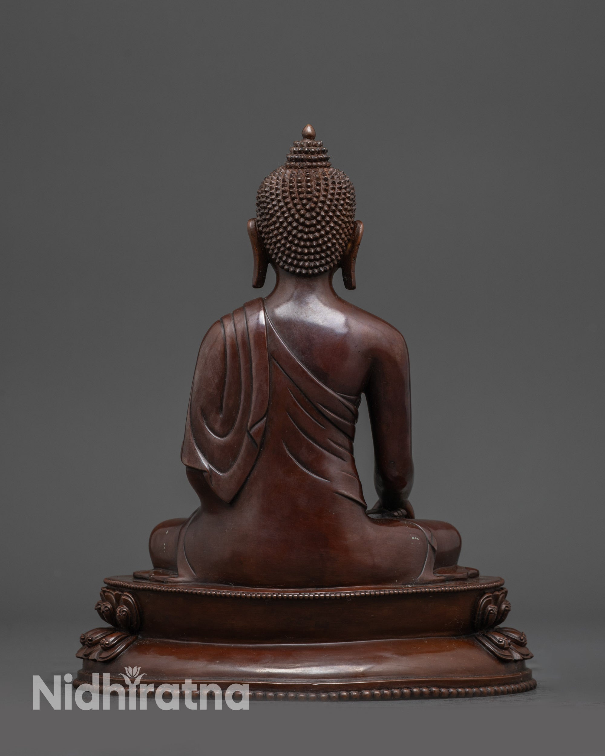 Back view of handcrafted Tibetan Buddha statue showing detailed lotus base