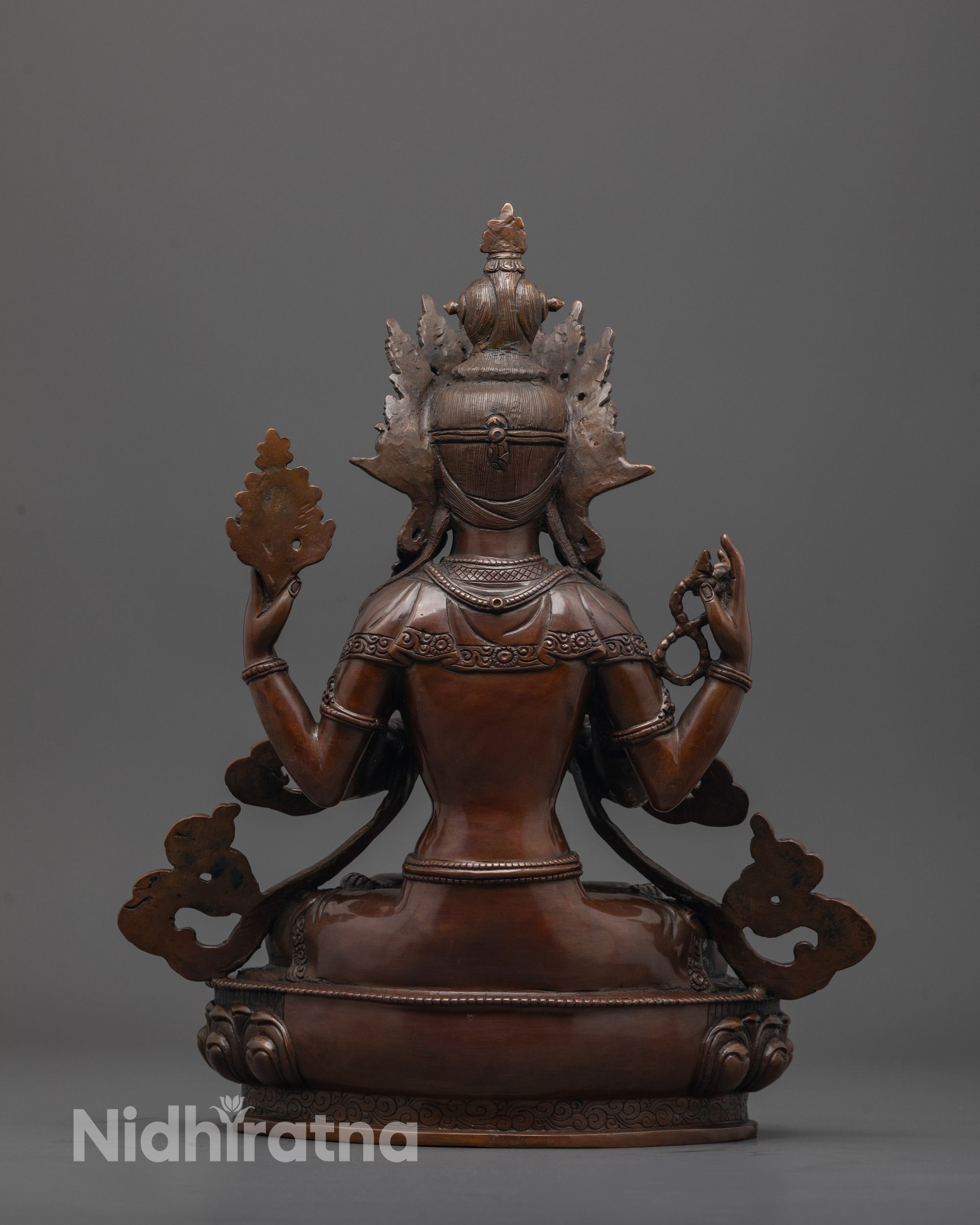 Back view of handmade oxidized Chenrezig statue with flowing robe and fine copper carving