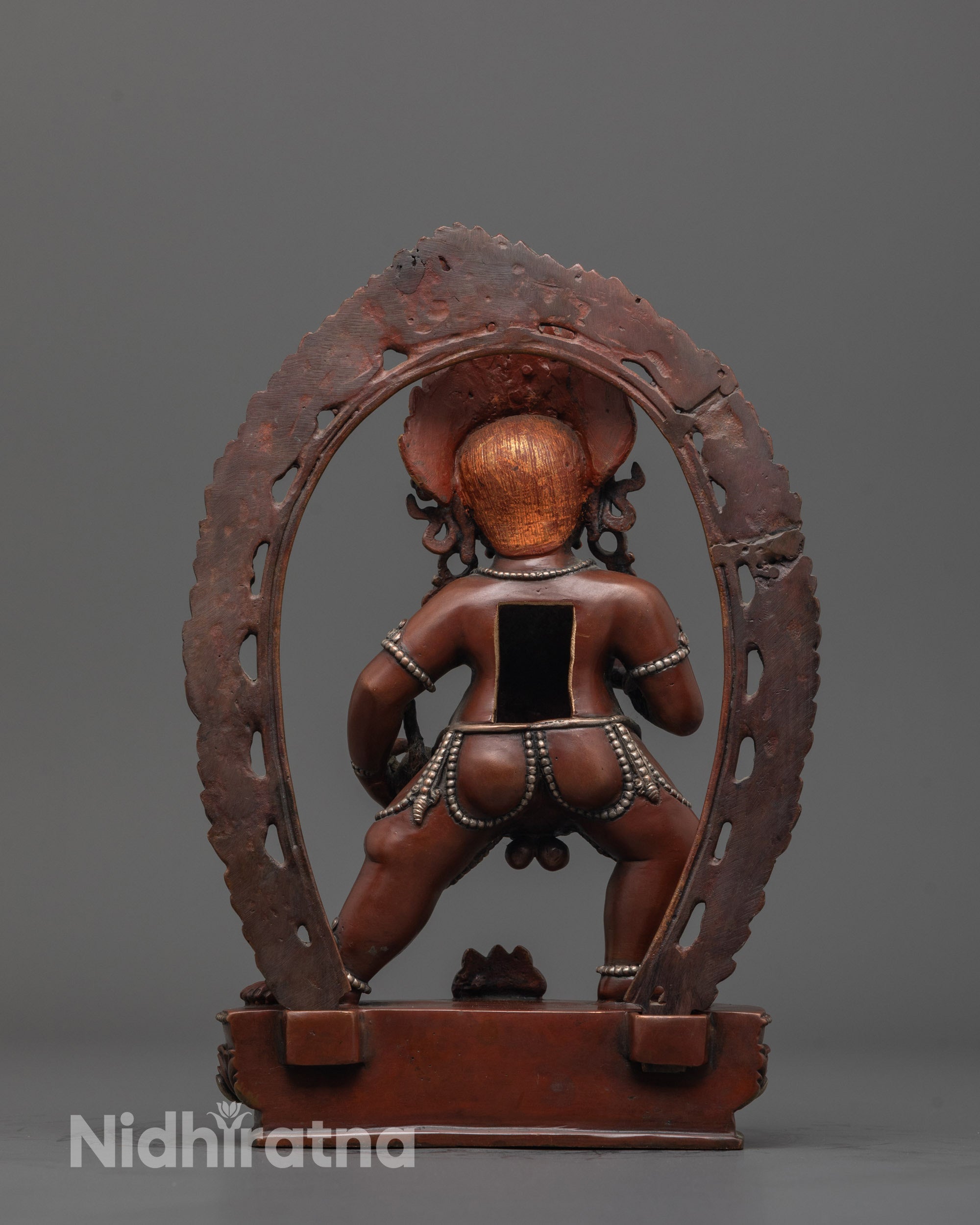 Back view of handmade oxidized copper Dzambhala statue with intricate silver plating details