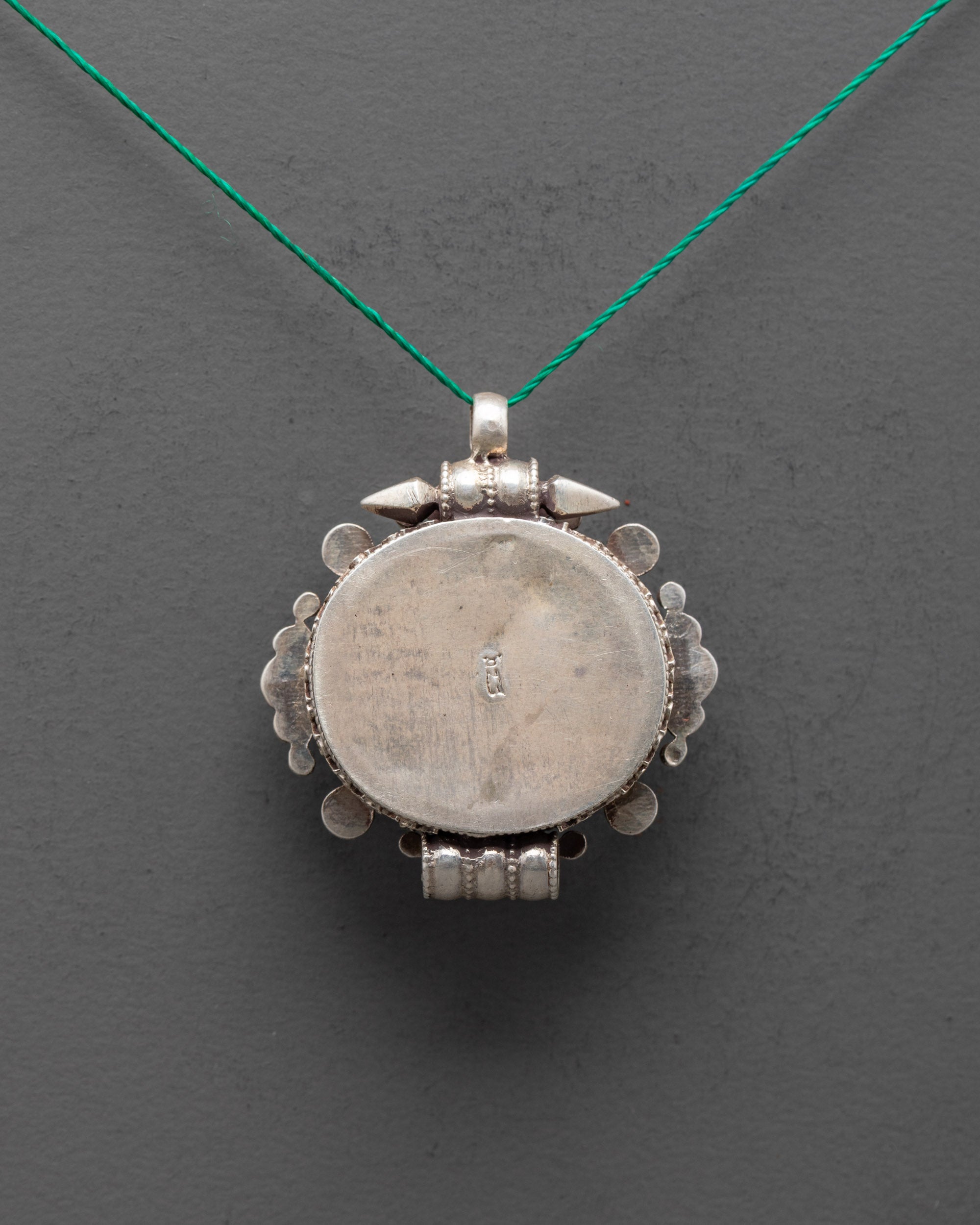 Back view of intricately carved silver locket pendant with traditional Himalayan craftsmanship