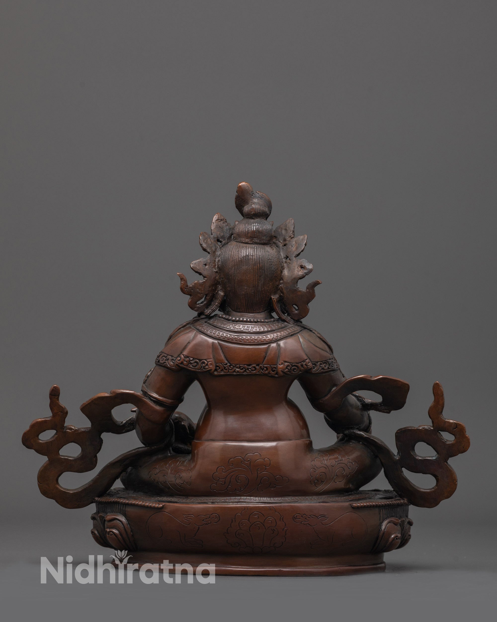 Back view of oxidized Dzambhala statue highlighting carved robe patterns and oxidized finish