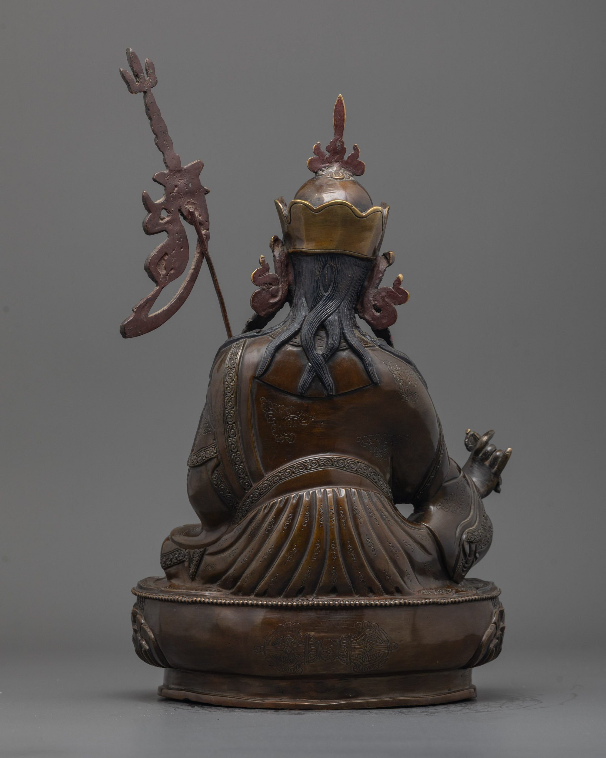 Back view of oxidized Guru Rinpoche Statue highlighting carved robe and lotus base