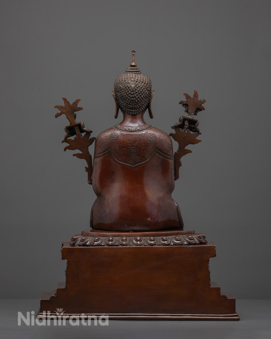 Back view of oxidized Maitreya Buddha statue showing intricate robe and throne carvings