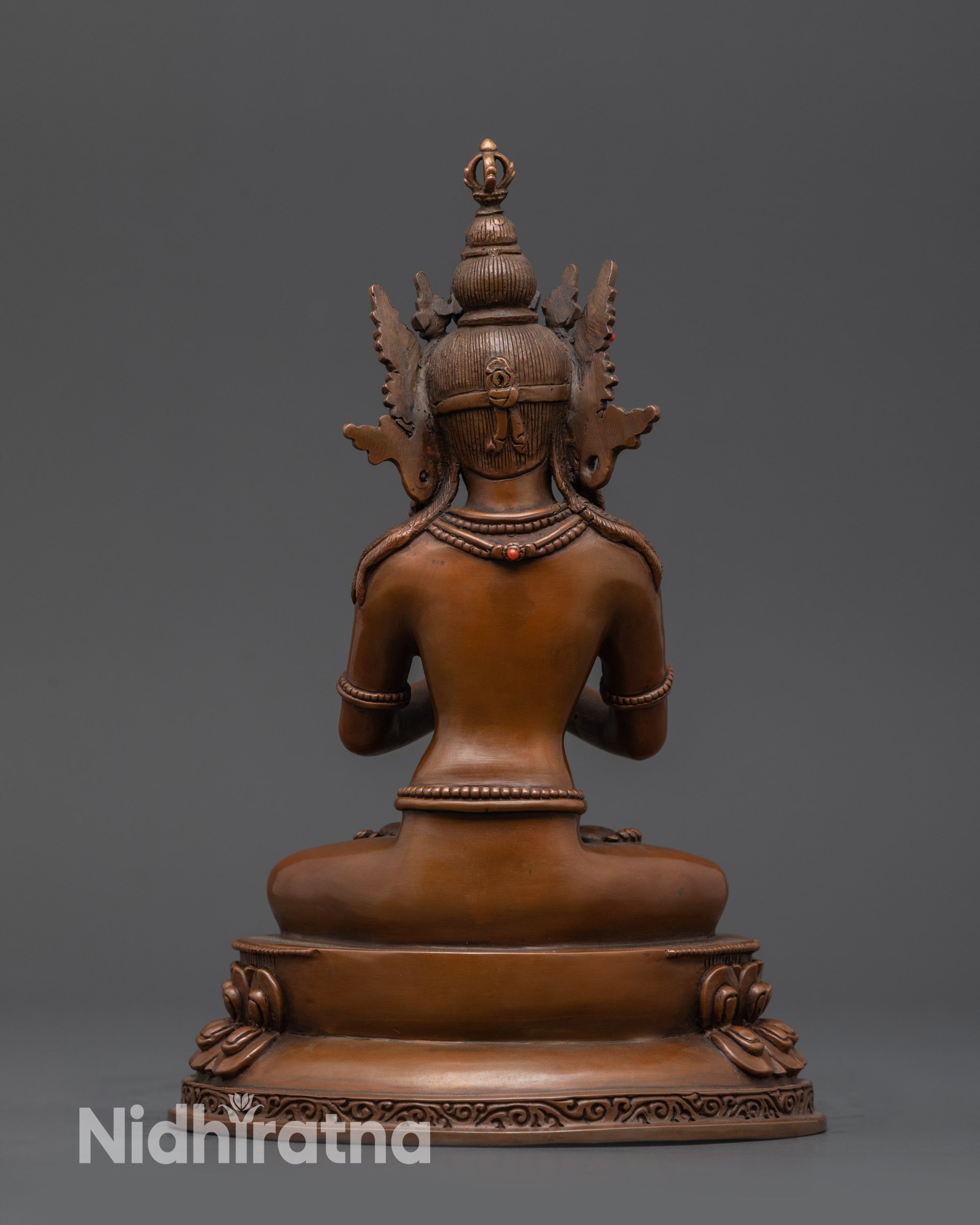 Back view of oxidized Vajradhara statue showing detailed jewelry and earthy hue