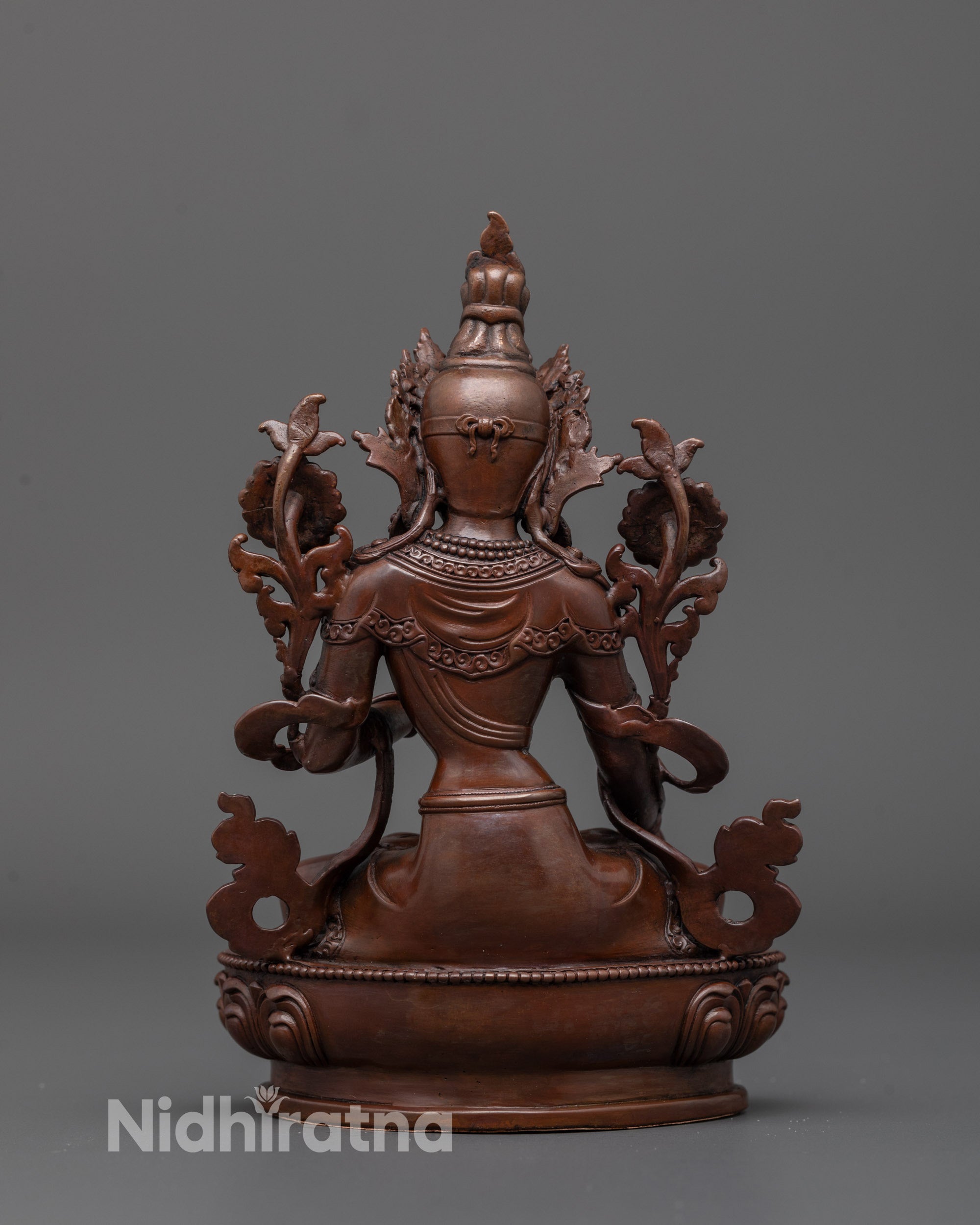 Back view of oxidized White Tara statue highlighting detailed flowing robes and lotus base