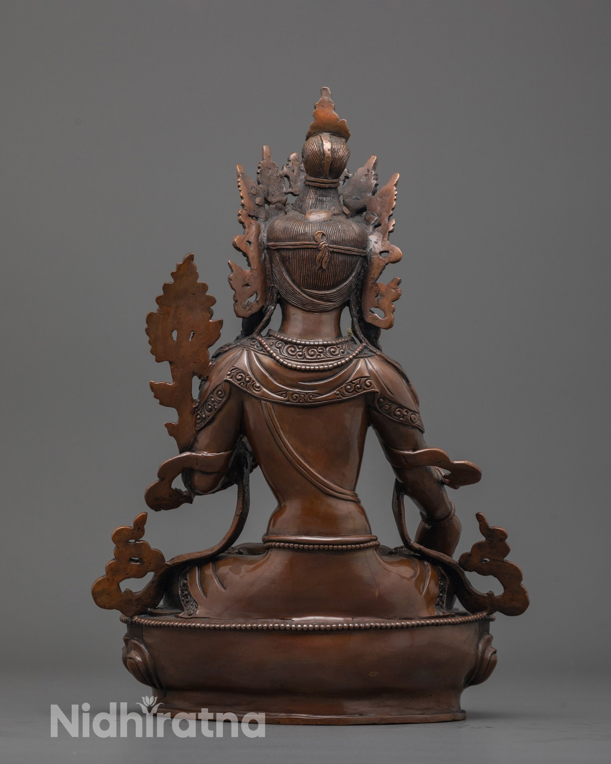 Back view of oxidized White Tara statue showing flowing carved robe and antique finish