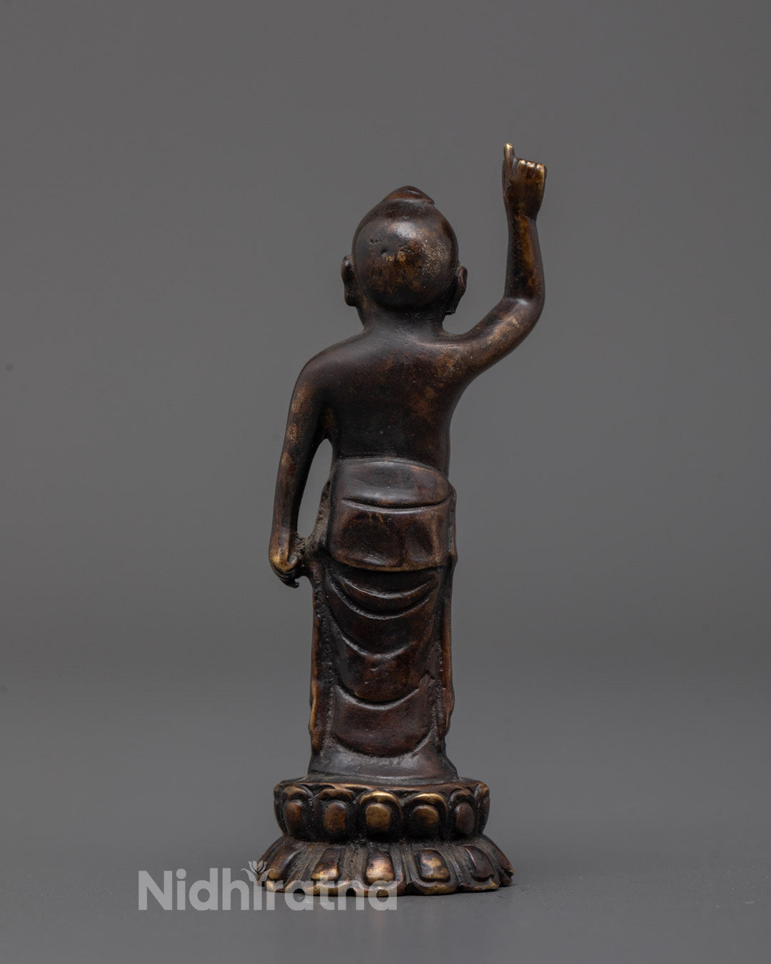 Back view of small oxidized copper Baby Buddha statue handmade in Patan, Nepal