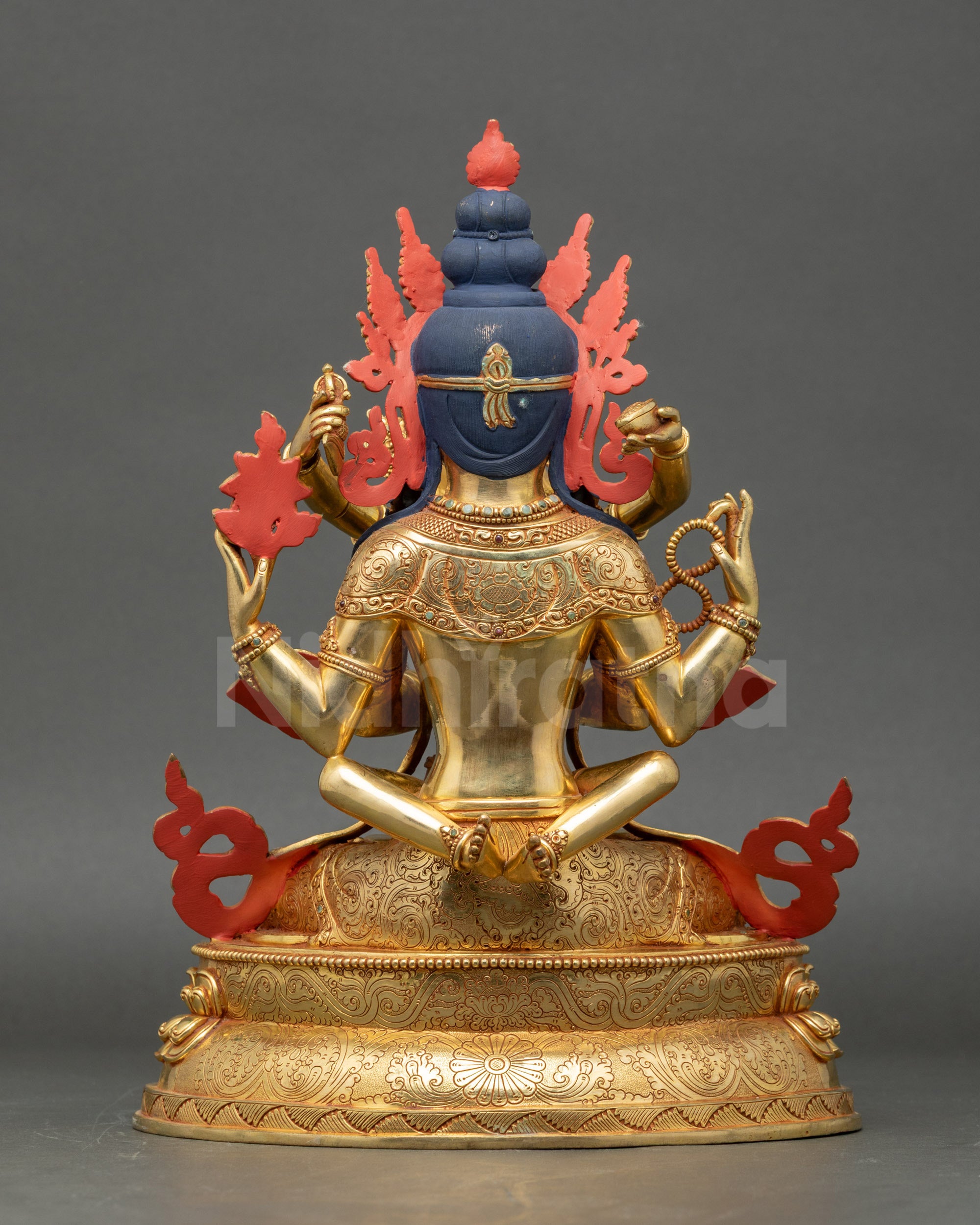 Back view of statue highlighting carved patterns and lotus pedestal