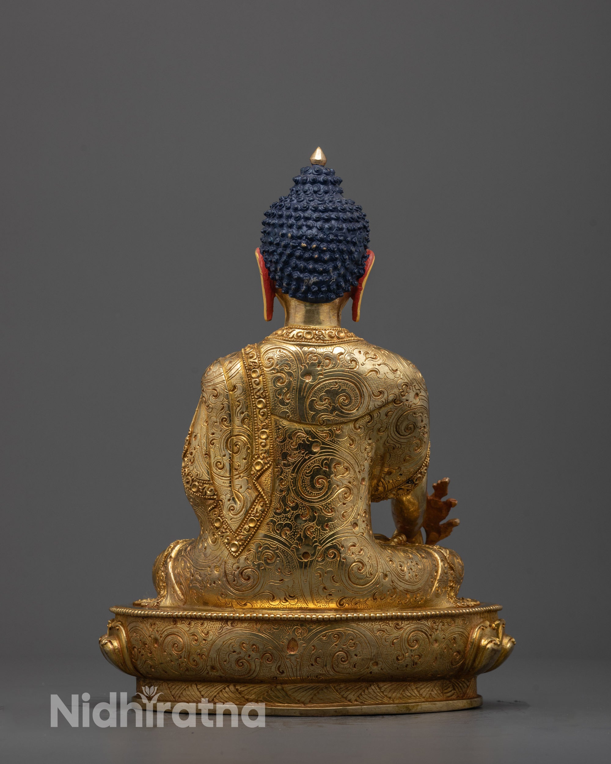 Back view of traditional Medicine Buddha statue with detailed carvings and halo