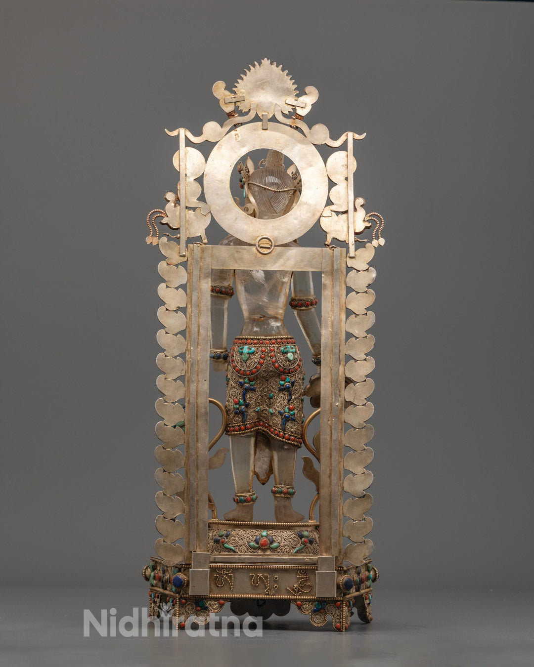 Back view of traditionally handcrafted Lokeshwor statue from Nepal, emphasizing copper texture and artisan stonework.