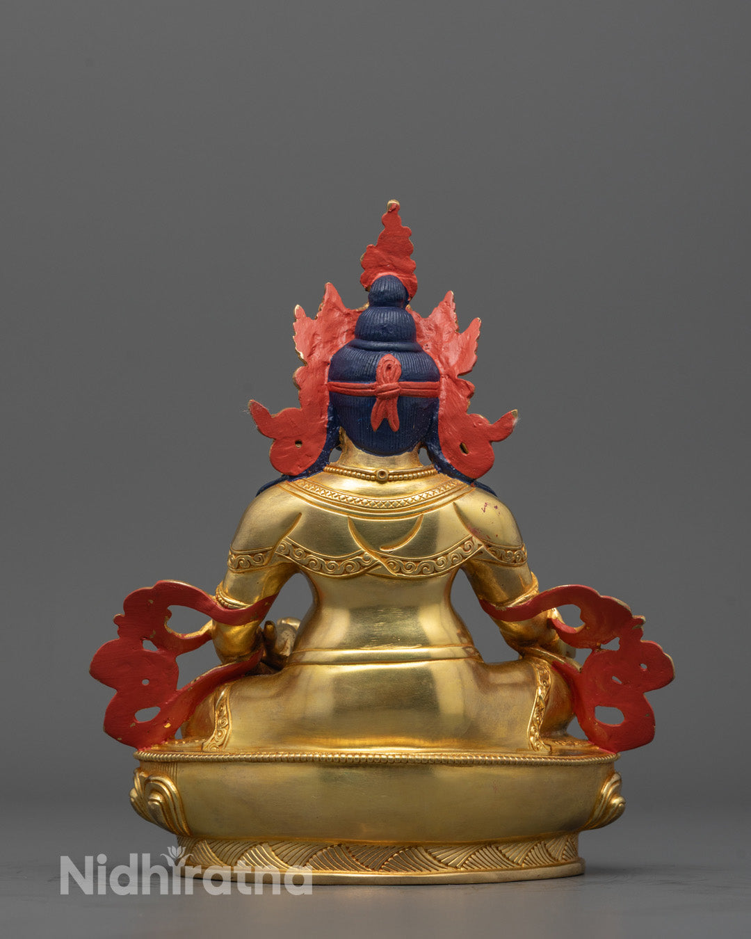 Backside of Dzambhala statue showing detailed craftsmanship and consecration chamber design