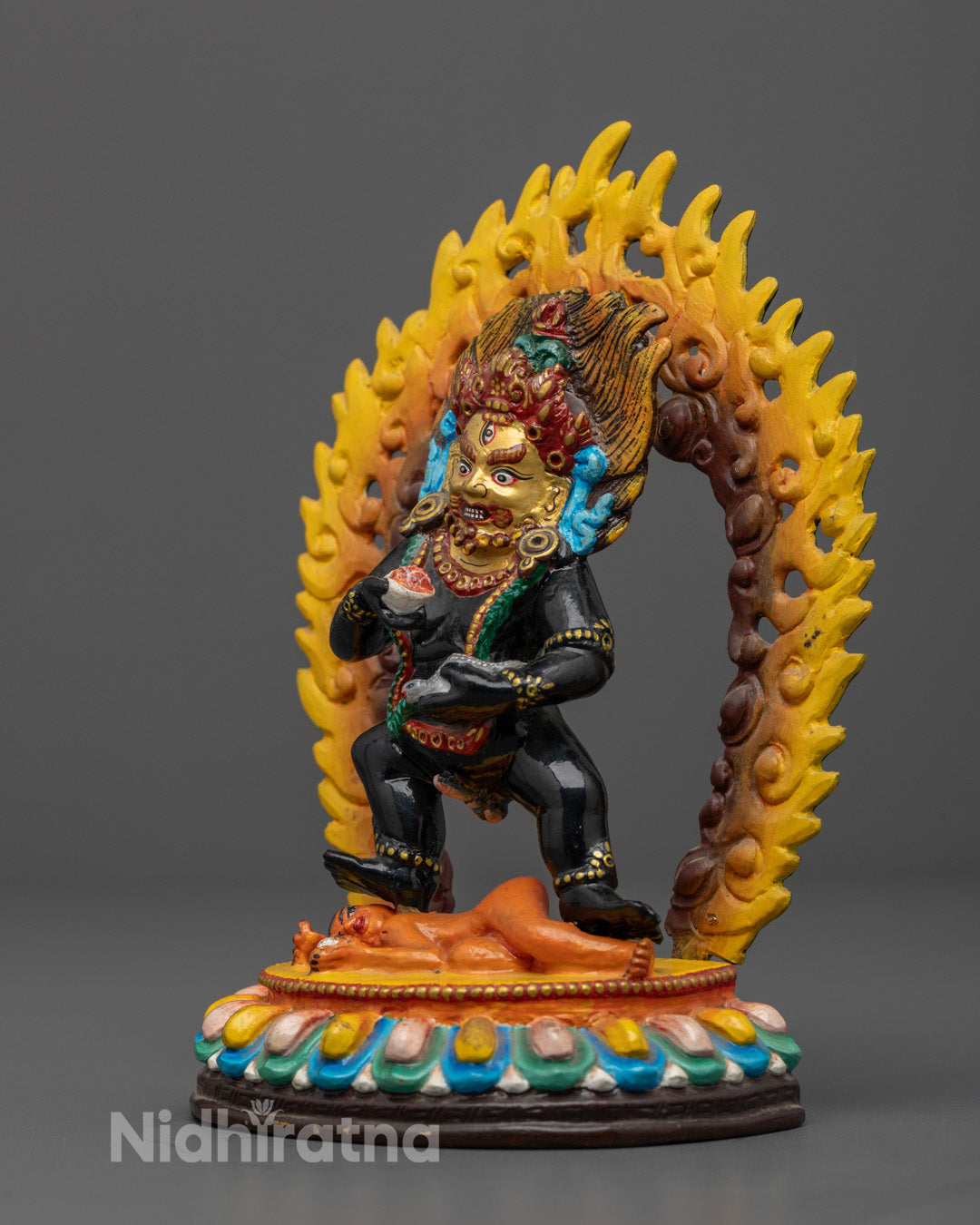 Black Dzambhala statue standing on lotus throne adorned with rich acrylic colors and intricate details