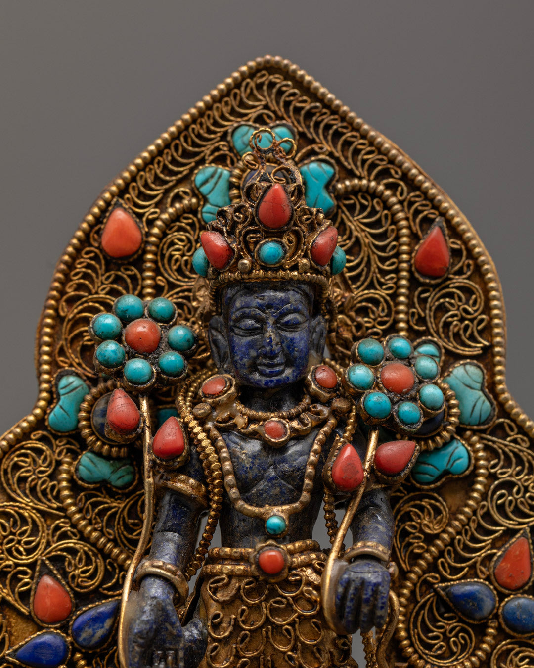 Blue stone Padmapani statue in meditative pose, adorned with gold and multi-color acrylic accents