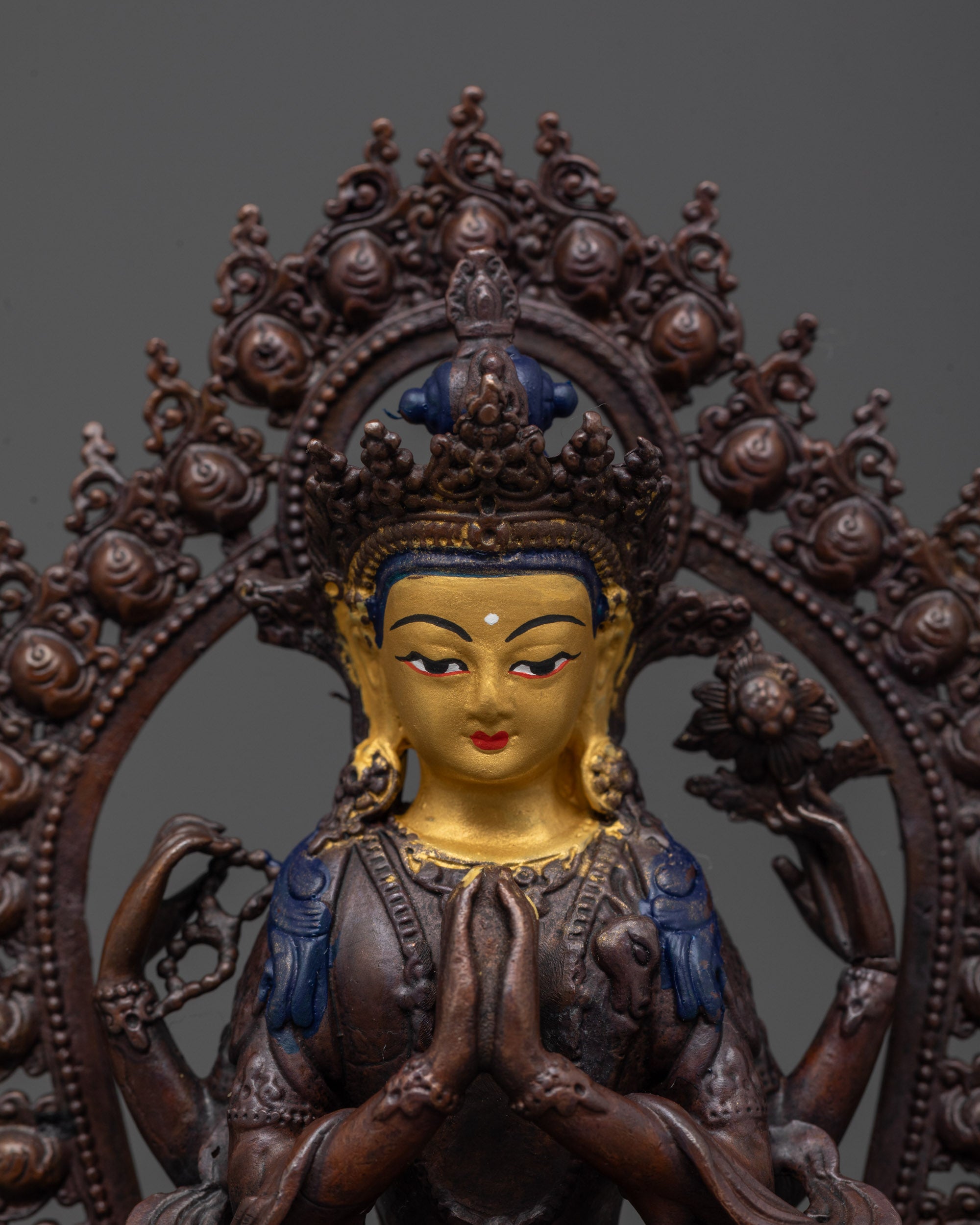 Close up of Chenrezig statue’s gold-plated face and five-jeweled crown with rosary detail