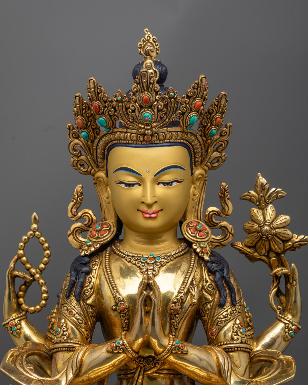 Chenrezig statue’s upper body showing fine craftsmanship, 24K gold gilding, and symbolic hand gestures holding sacred objects