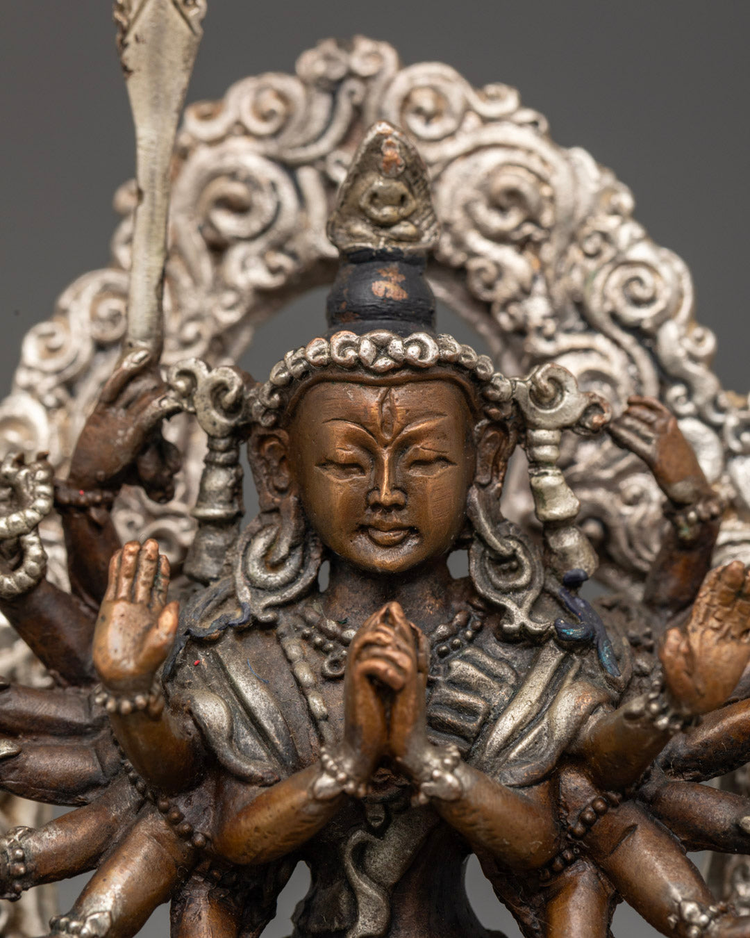 Chundi Devi statue displayed on a Tibetan altar, surrounded by candles and prayer items, invoking blessings and divine protection.