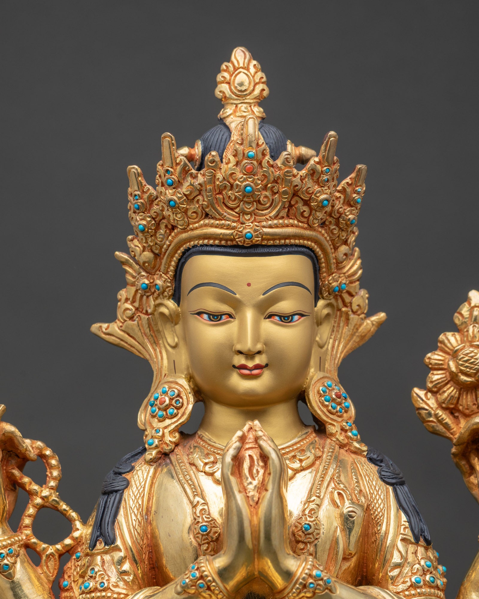 Close up of Four Armed Chenrezig statue gold fire gilded copper Avalokiteshvara detail