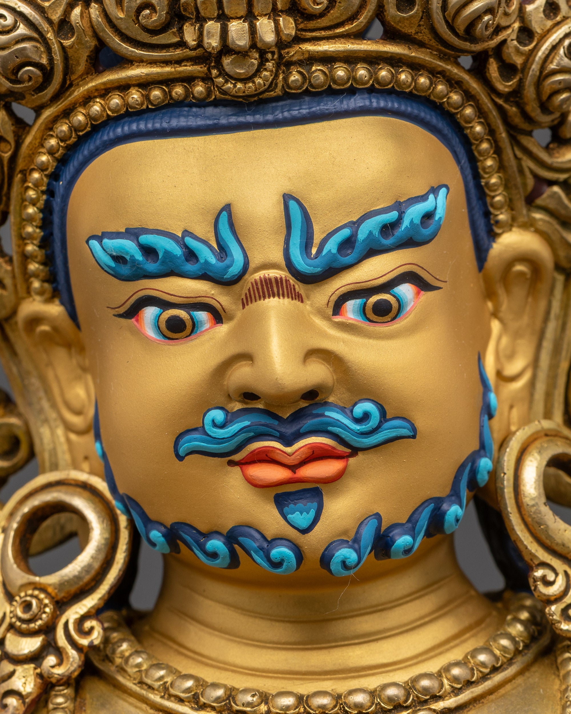 Close-Up Angle of Dzambhala’s Wrathful Yet Compassionate Gold-Gilded Face