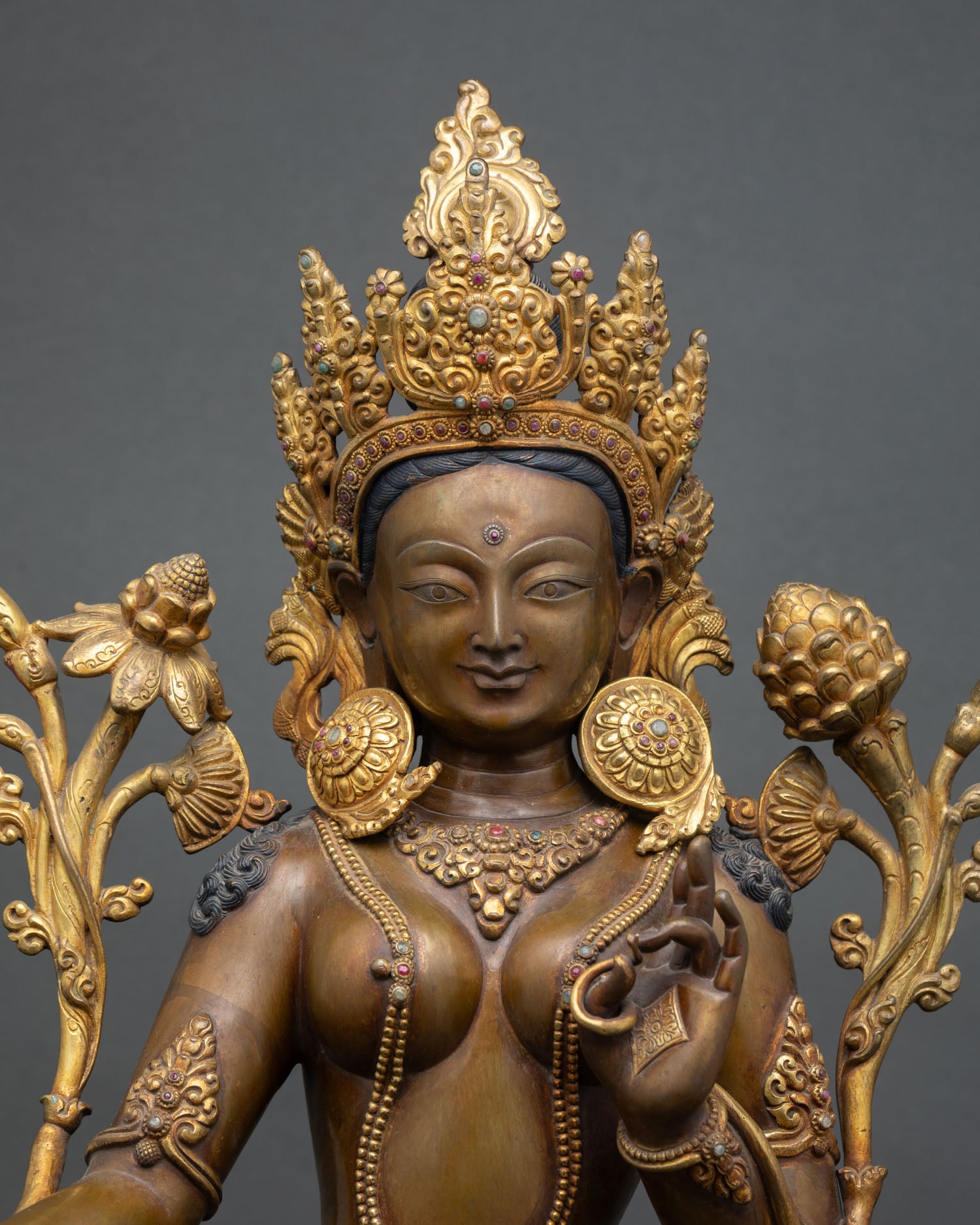 Close-up Green Tara statue, oxidized copper texture, crown and jewelry details