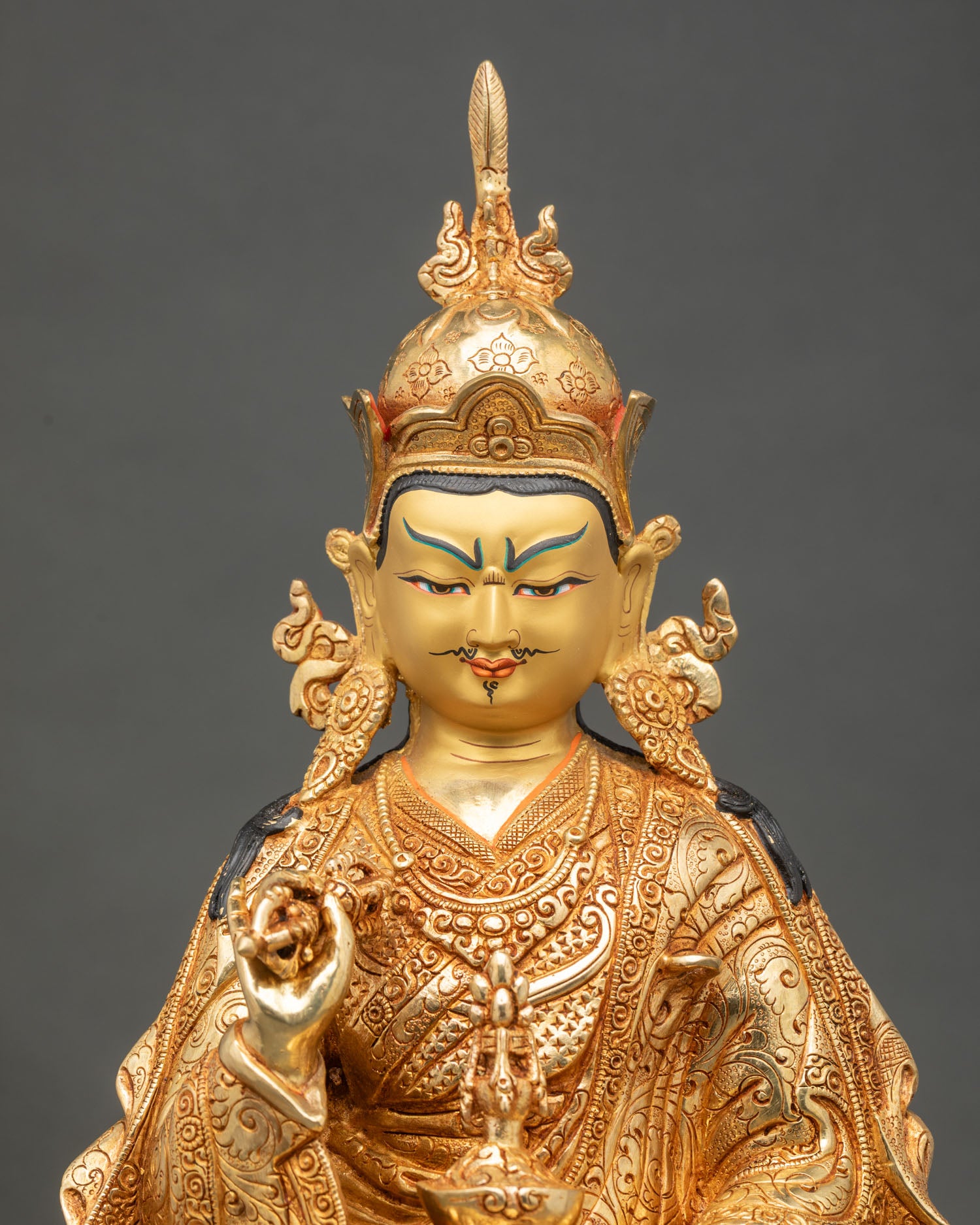 Close up Guru Tsokye Dorje statue semi-wrathful face intricate robes khatvanga and vajra