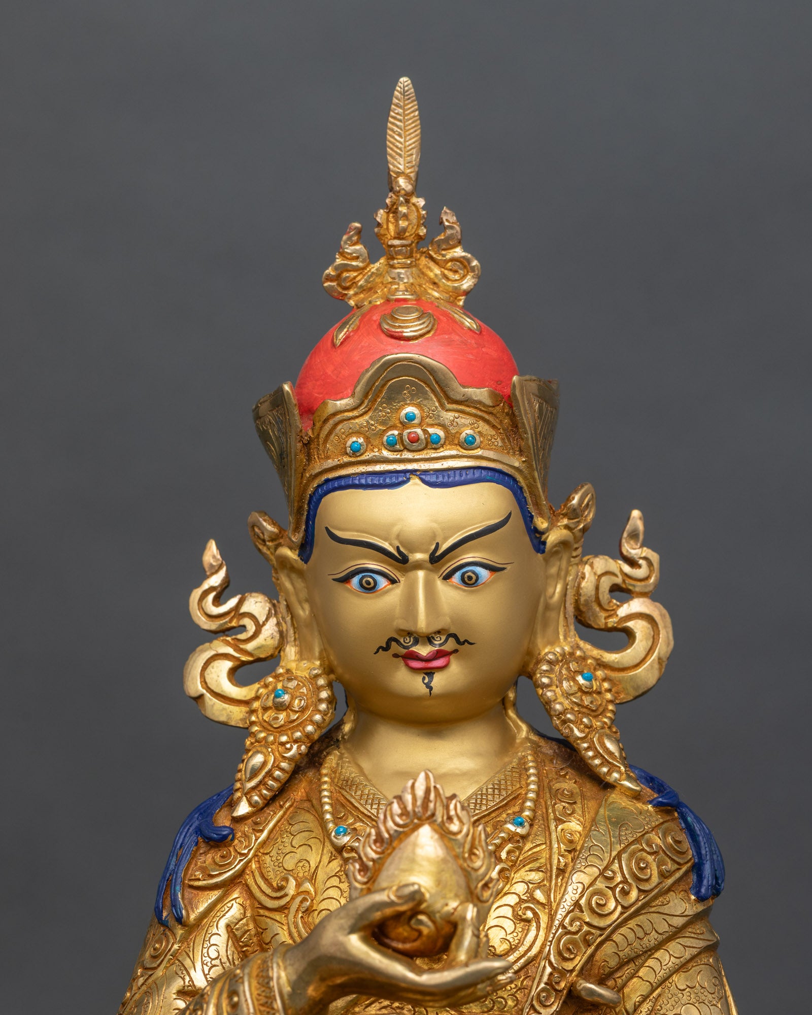 Close up of Guru Norlha statue showing gold gilded copper details and lotus hat