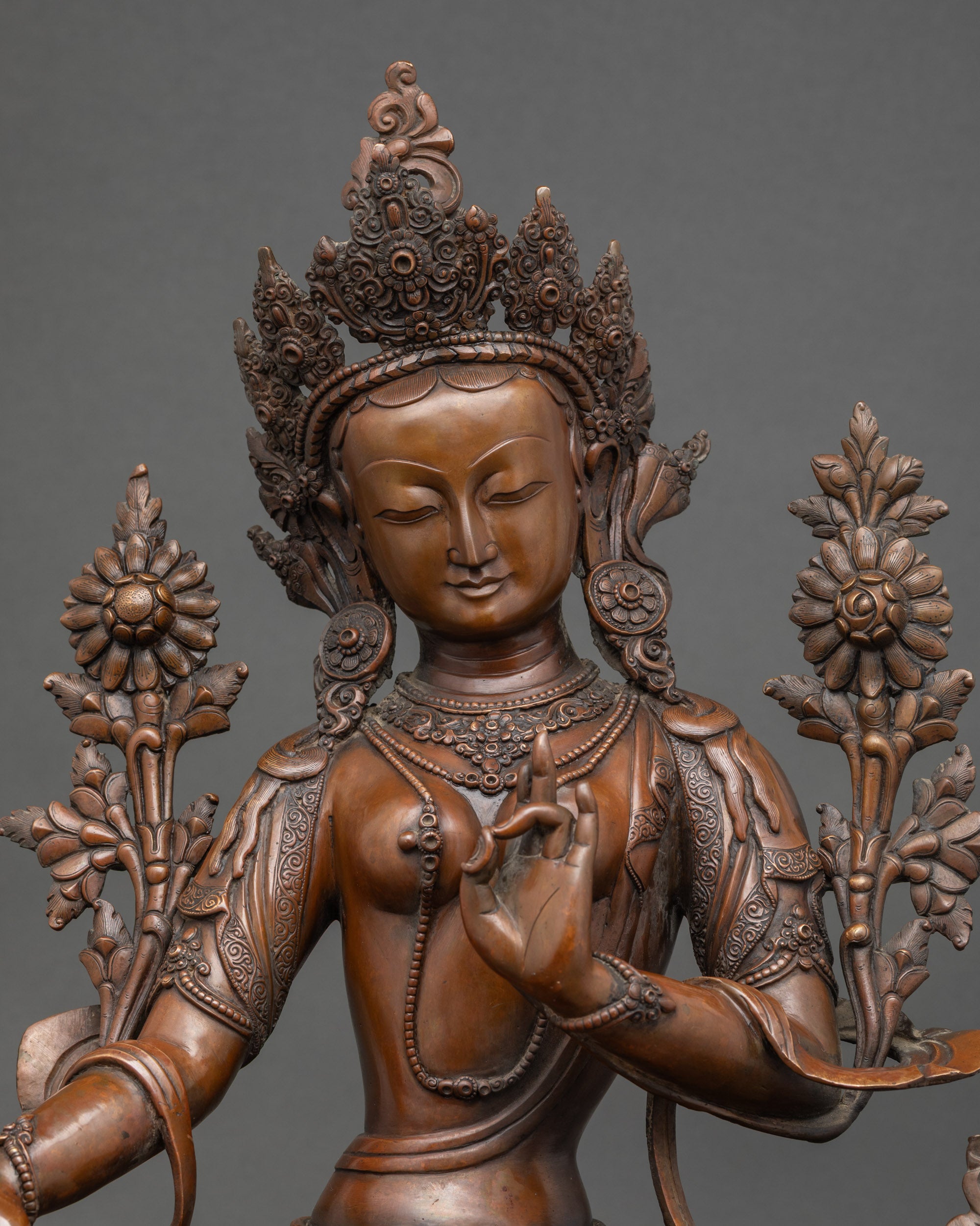 Close-up Green Tara statue oxidized copper detailing, serene seated Buddhist deity