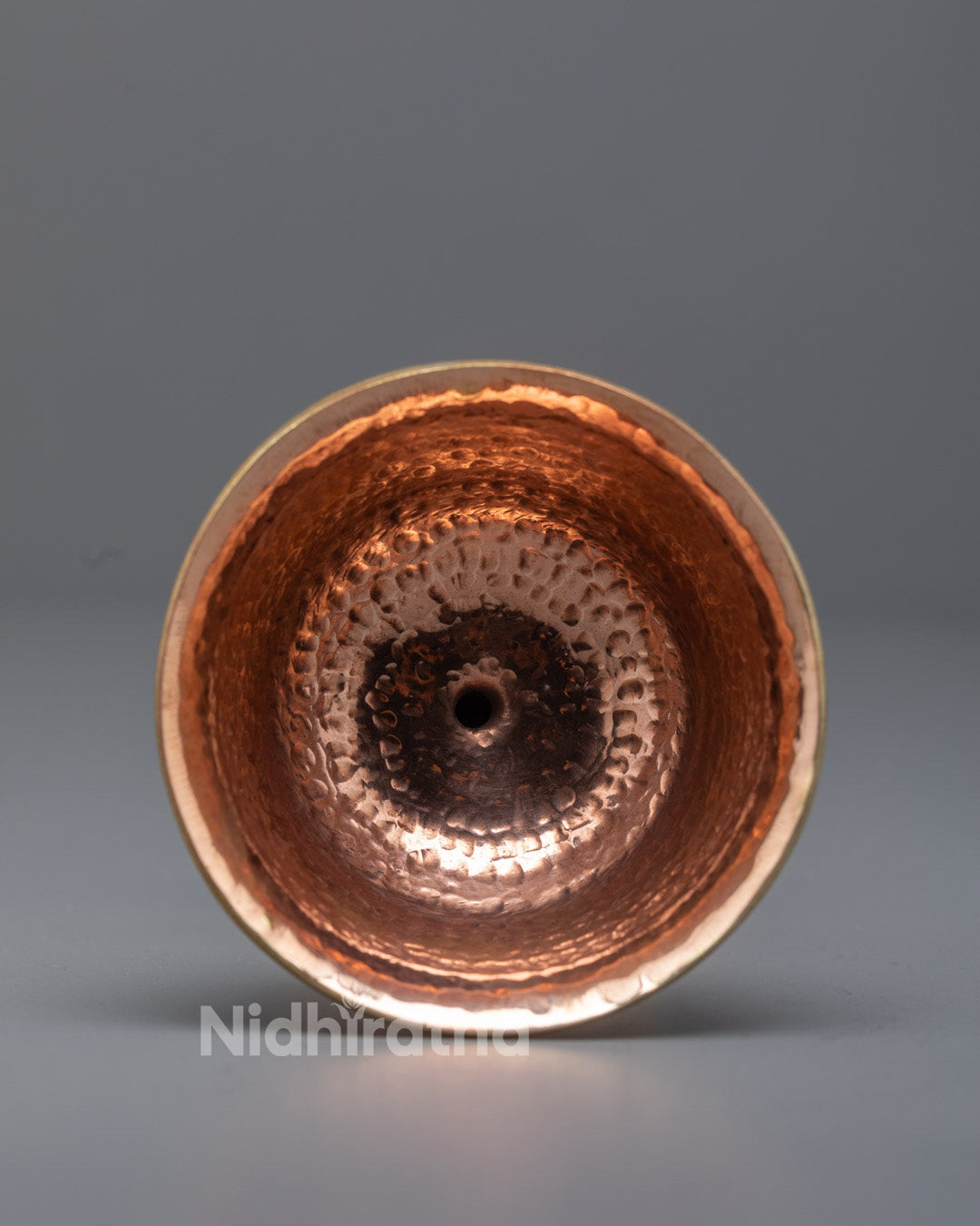 Close-up angled shot of traditional copper butter lamp glowing with flickering flame
