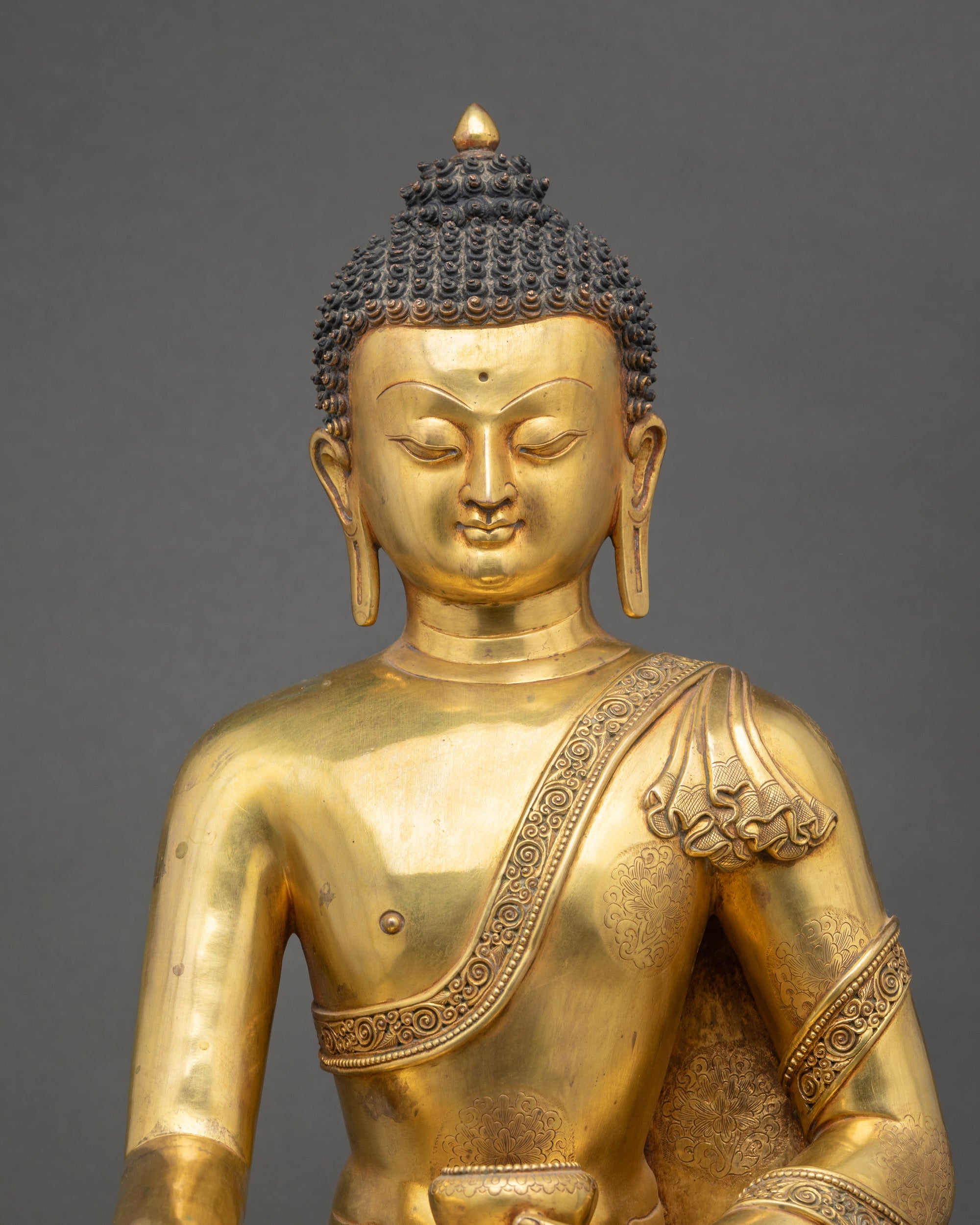 Close-up detail of auspicious symbols carved on Shakyamuni Buddha robes by Newari artisans