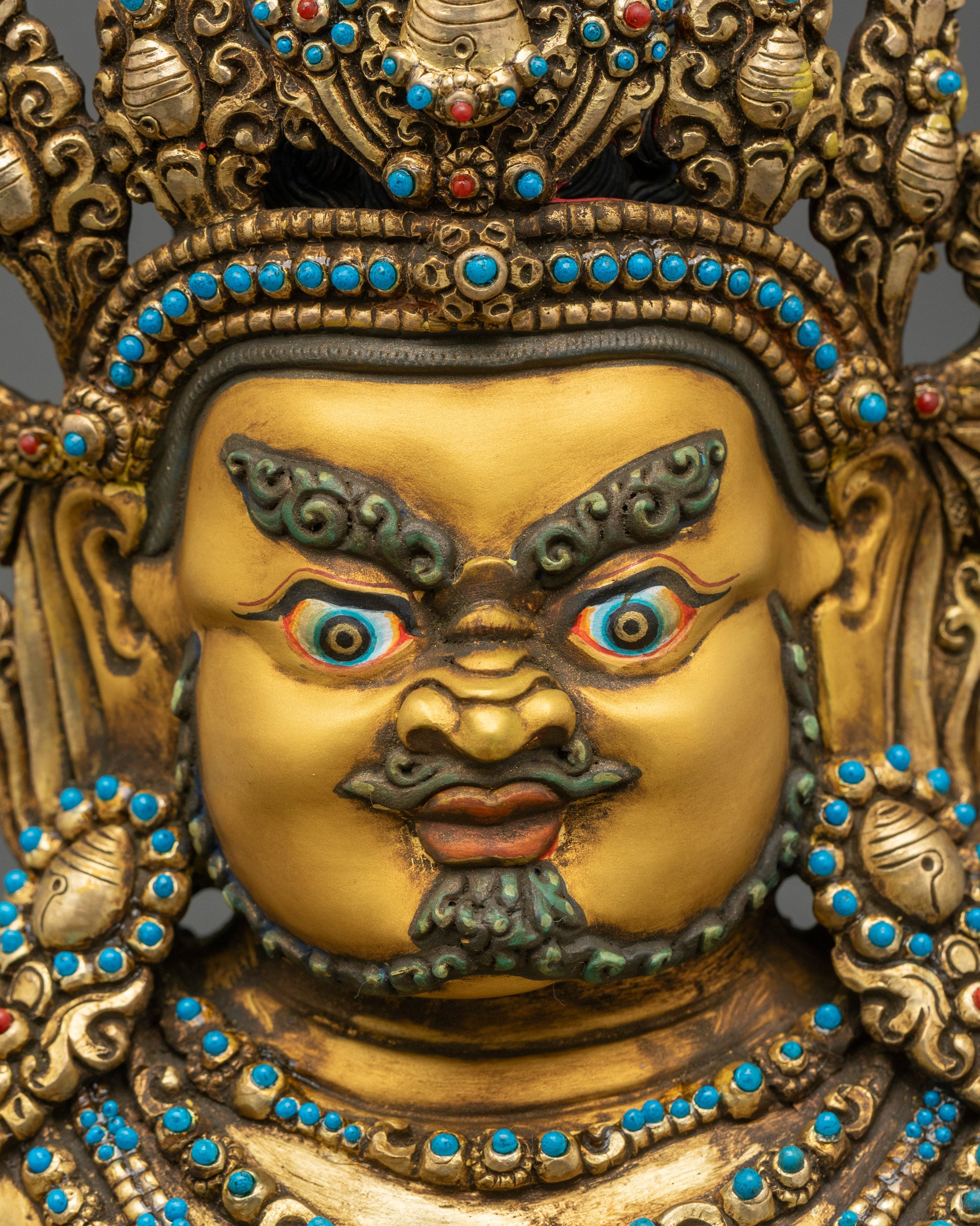 Close-up o f Dzambhala sculpture showing intricate gold robes and protective ornaments