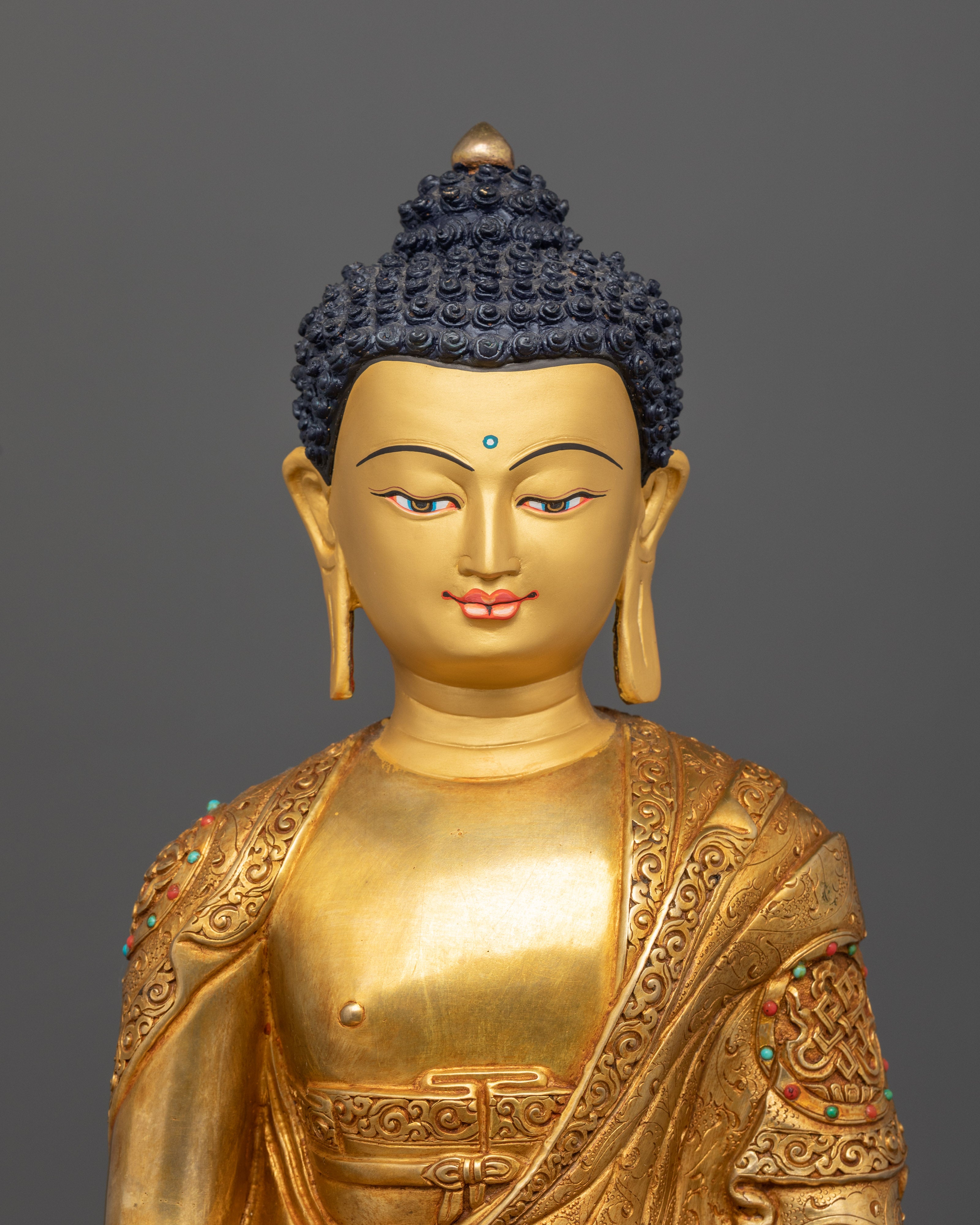 Close-up of Amitabha Buddha’s face and semi-precious stones on auspicious symbols