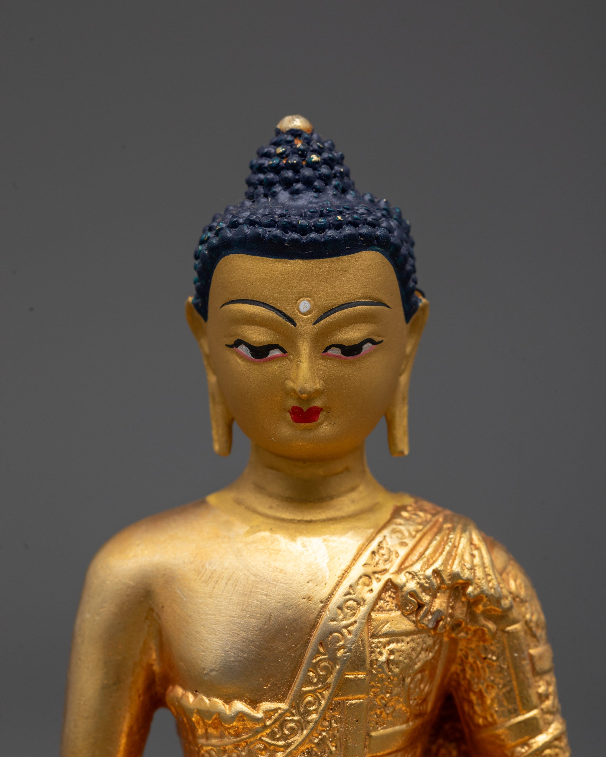 Close-up of Amitabha Buddha's serene face and 24k Gold Coated face