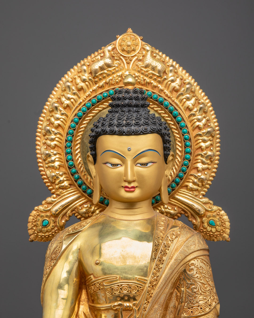 Close-up of Buddha's serene face with 24k gold gilding and artistic craftsmanship